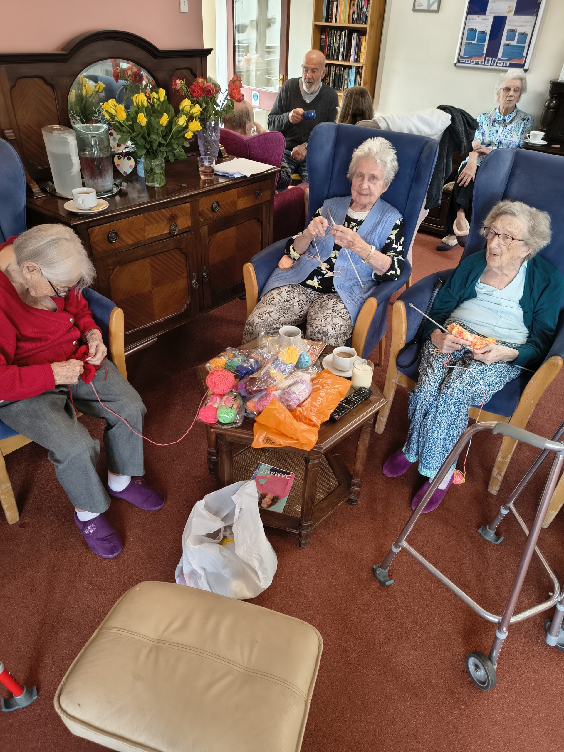 Elderly women knitting in communal space.