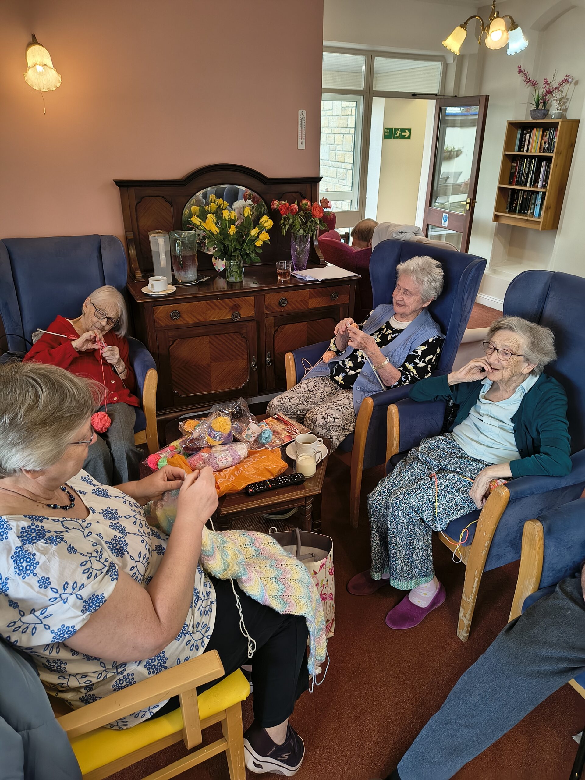 Elderly residents knitting in lounge