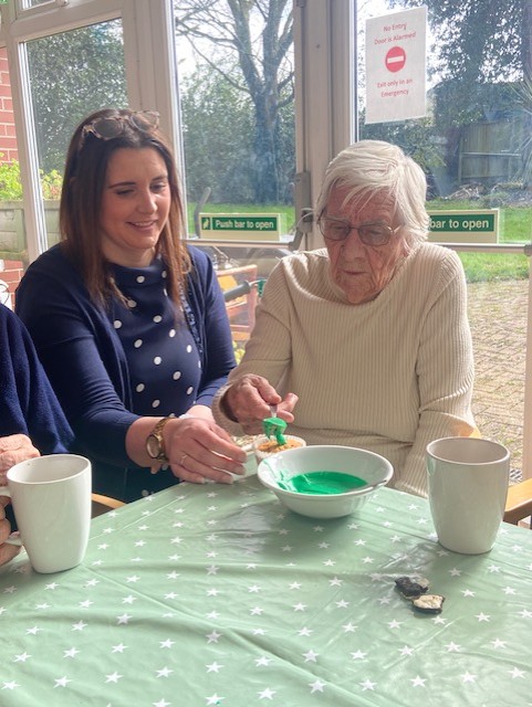 Resident putting green icing on a cupcake
