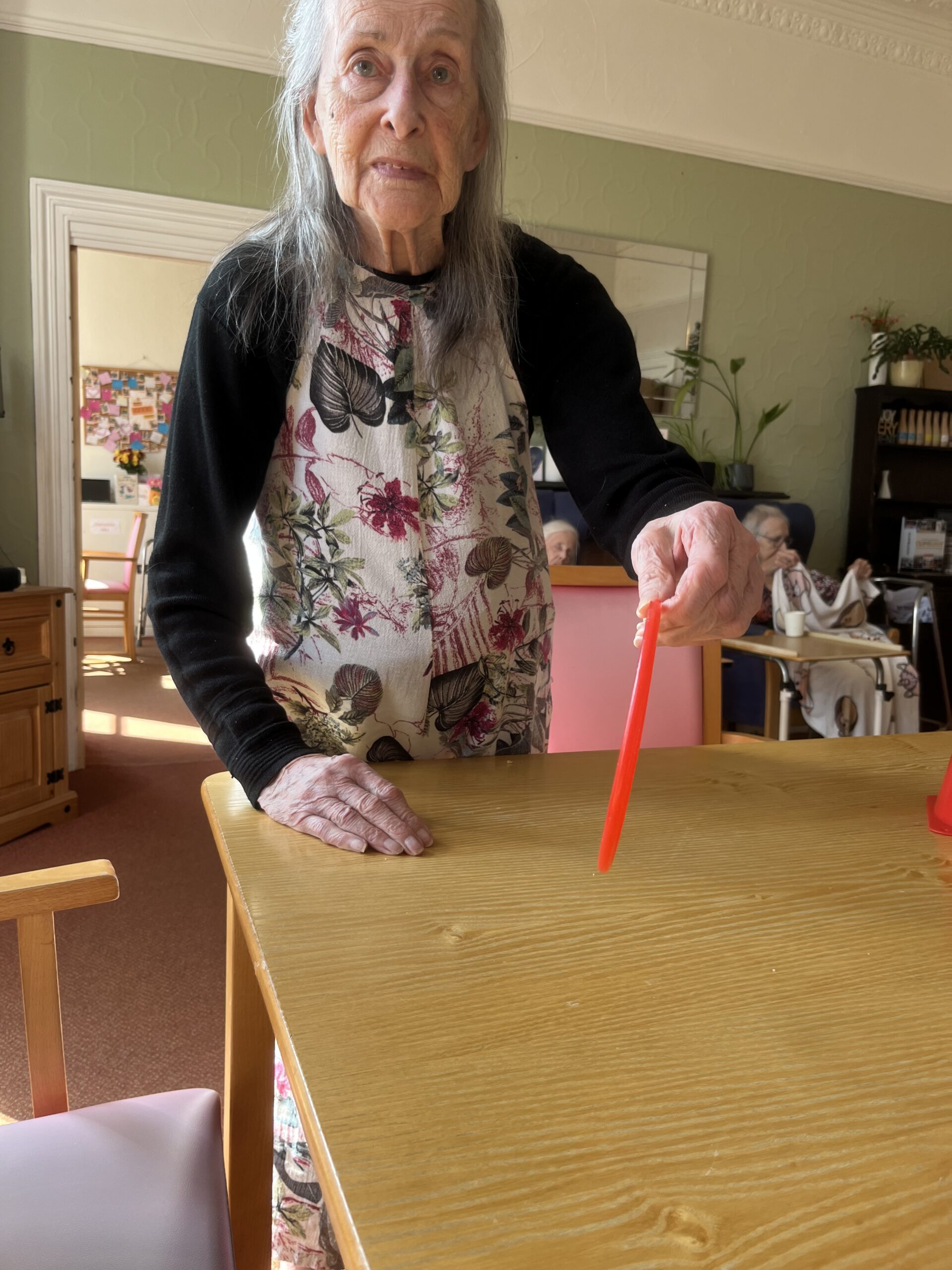 Resident throwing hoops onto cones on a table
