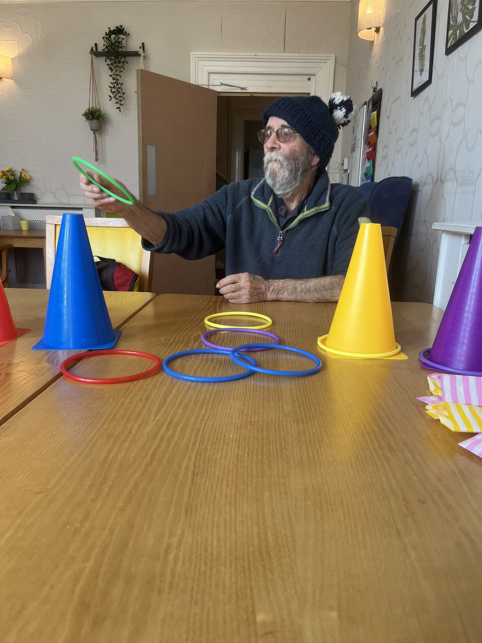 Resident throwing hoops onto cones on a table