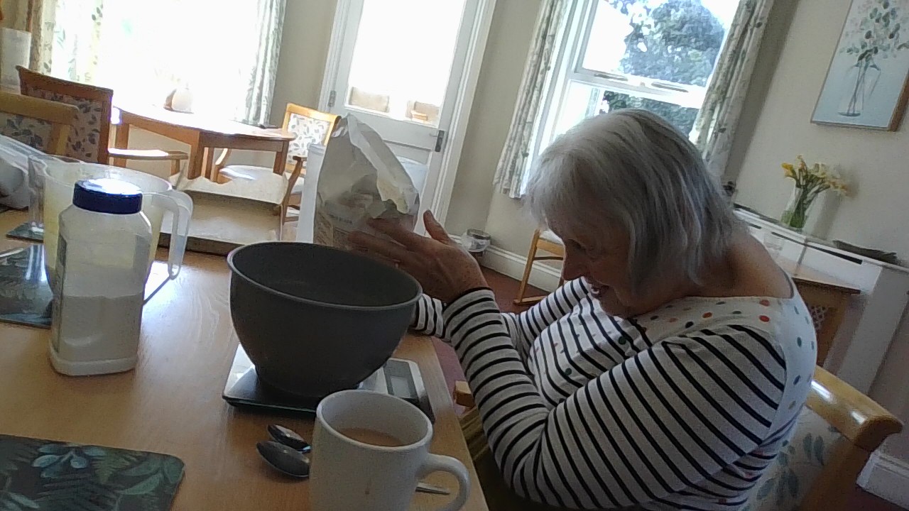 Resident weighing flour into a bowl
