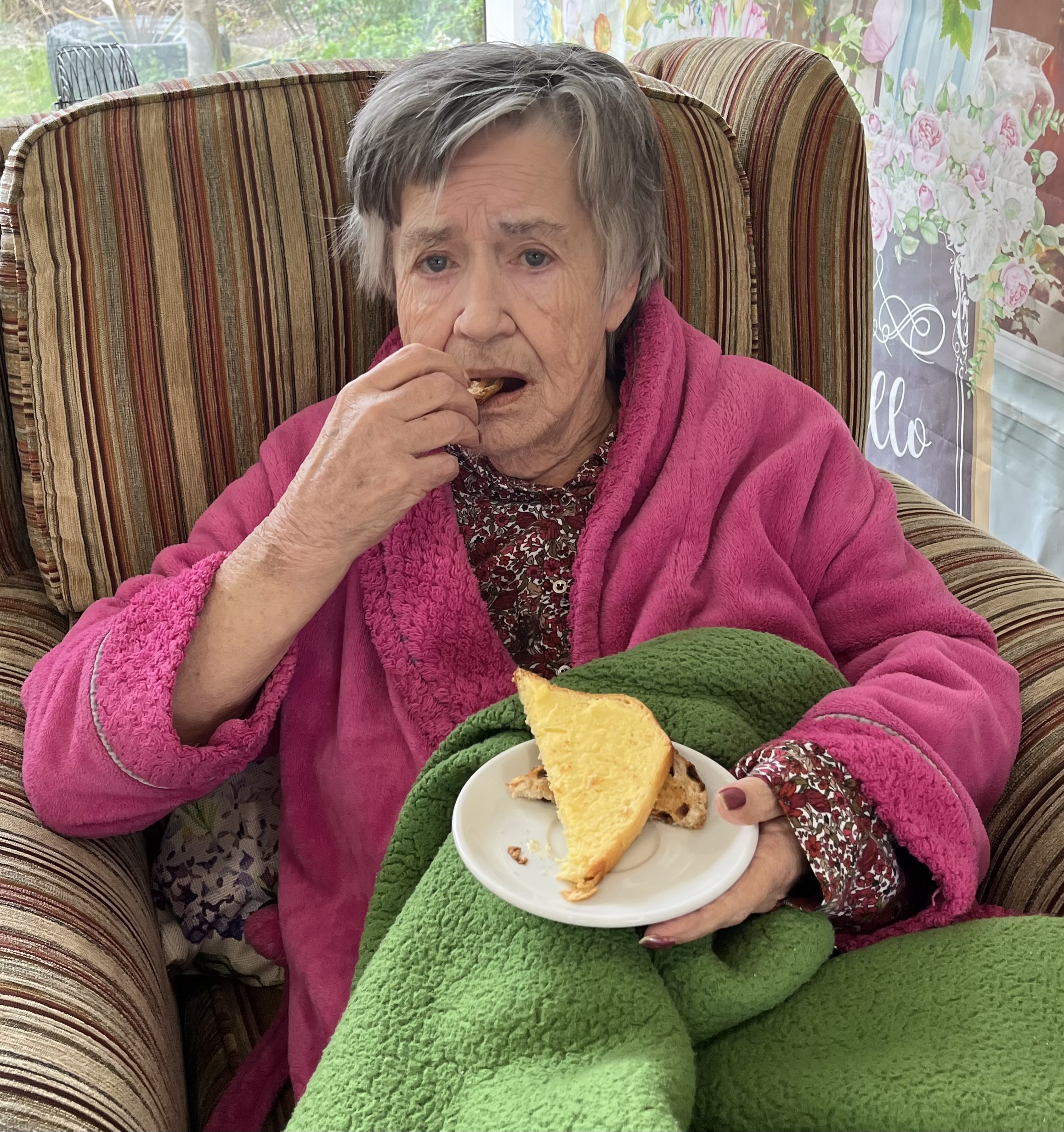 Resident enjoying a slice of sweet loaf and a cup of tea