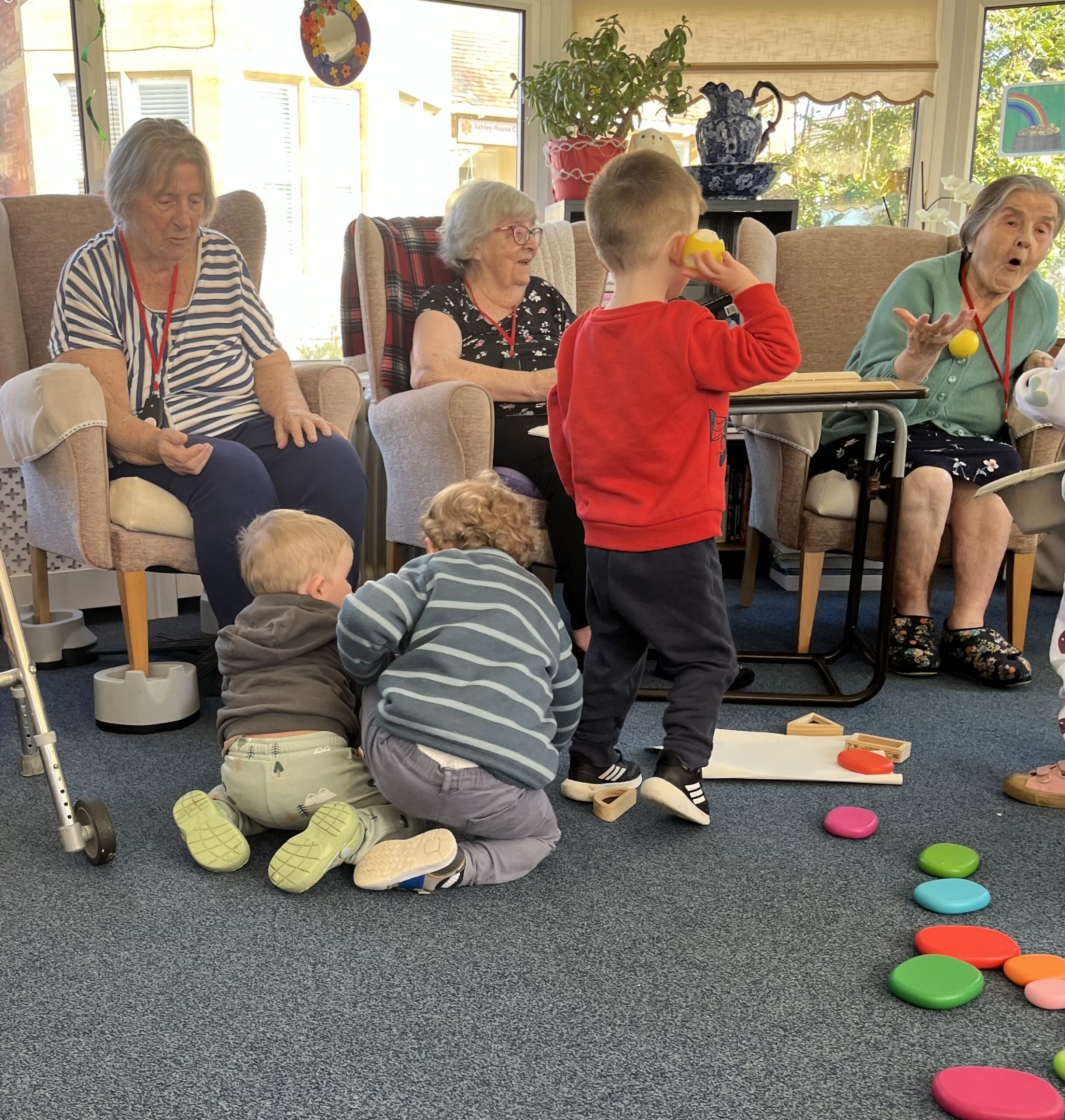 Toddlers and residents playing with tennis balls scaled