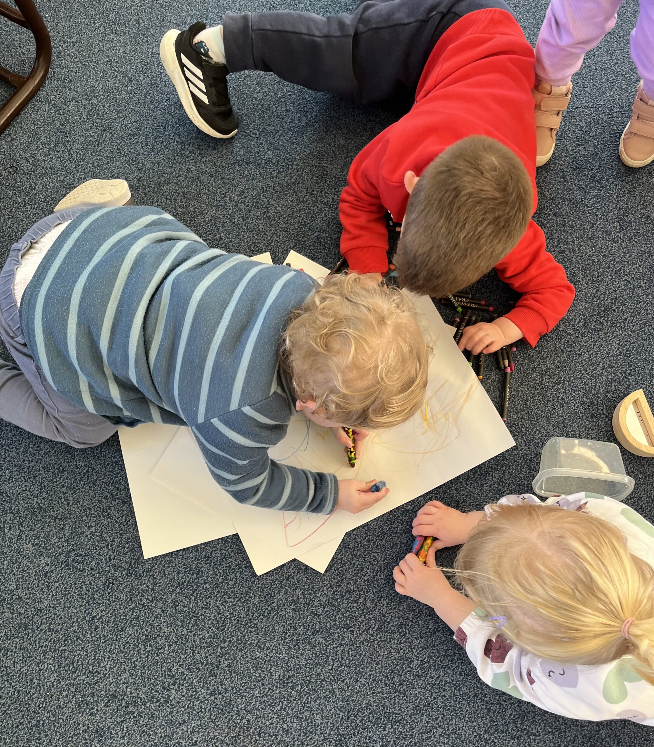 Toddlers playing on the floor with paper and crayons 2 scaled