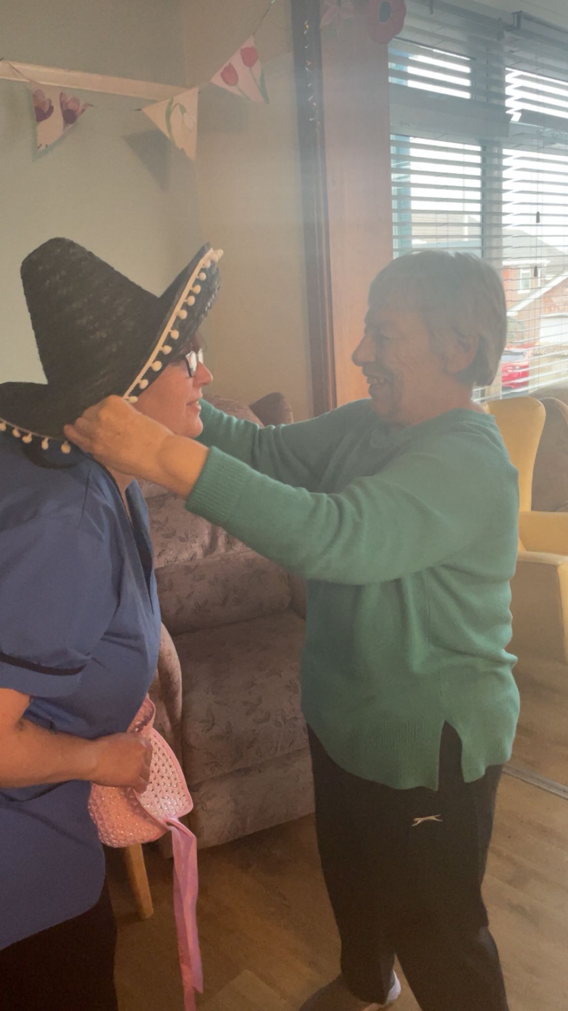 Ange putting the sombrero on Paula