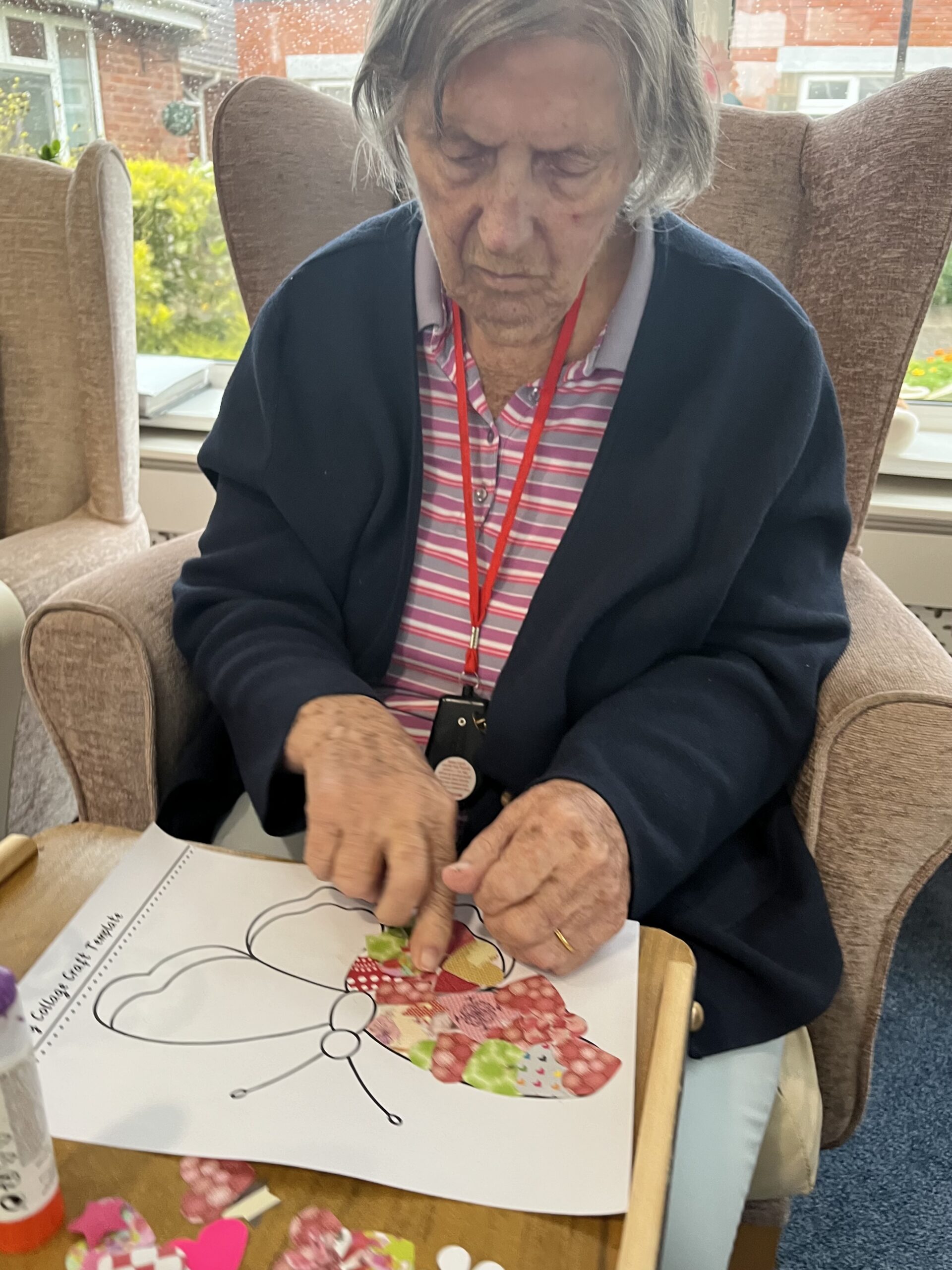 Barb sticking patterned paper to her butterfly