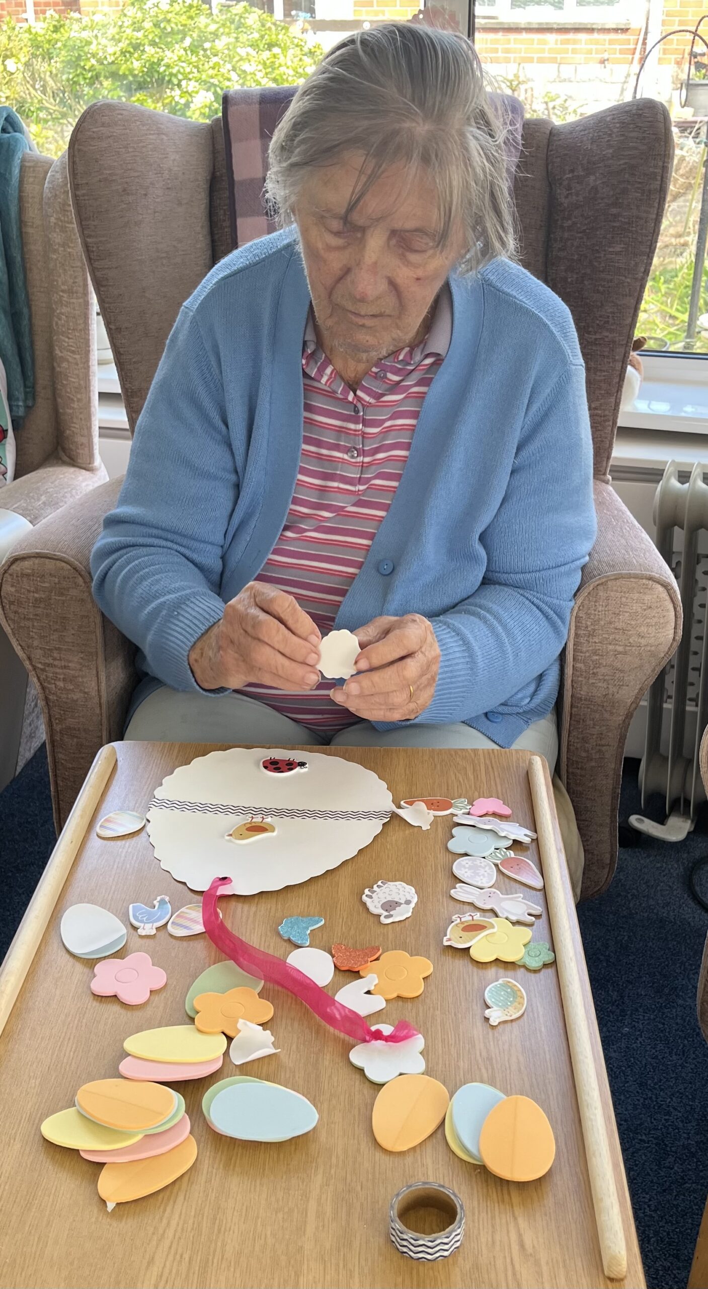 Barb sticking sheep and bird stickers on to her egg shaped paper scaled