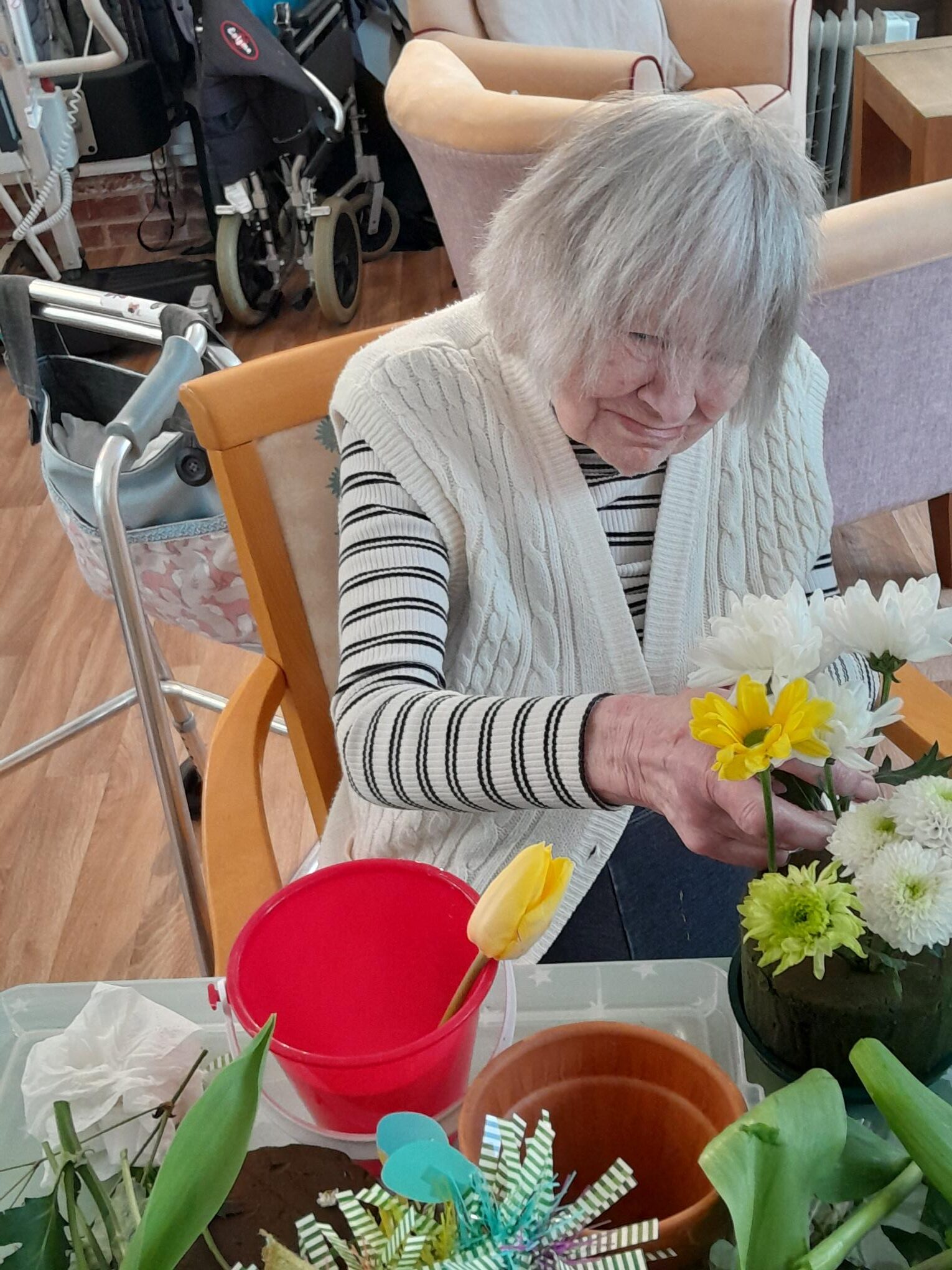 Female resident arranging white and yellow flowers rotated