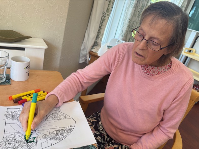 Female resident colouring in a shield with St Georges day motifs