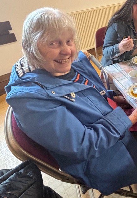 Female resident enjoying the refreshments smiling for the camera
