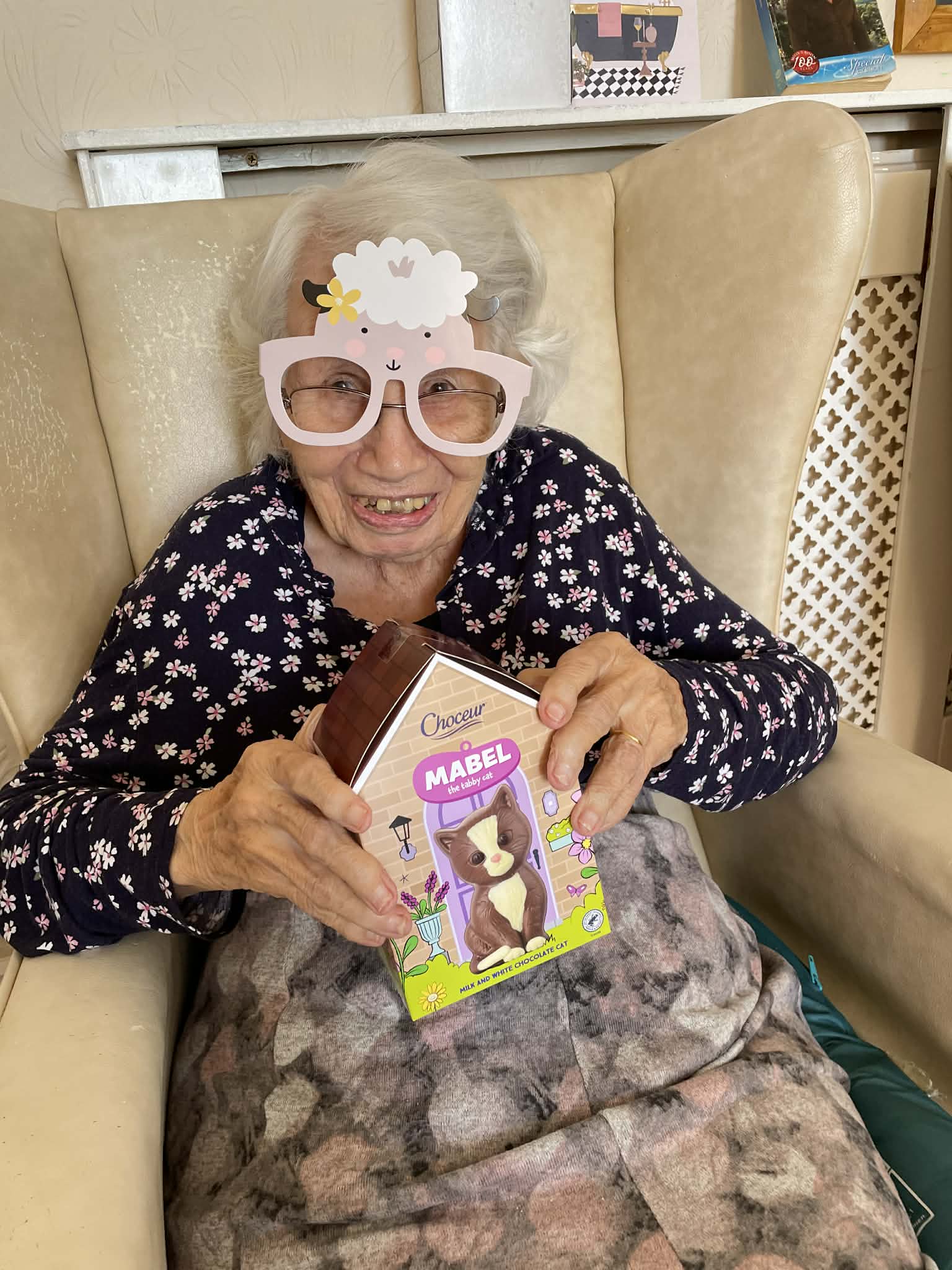 Female resident holding a chocolate cat and wearing sheep glasses
