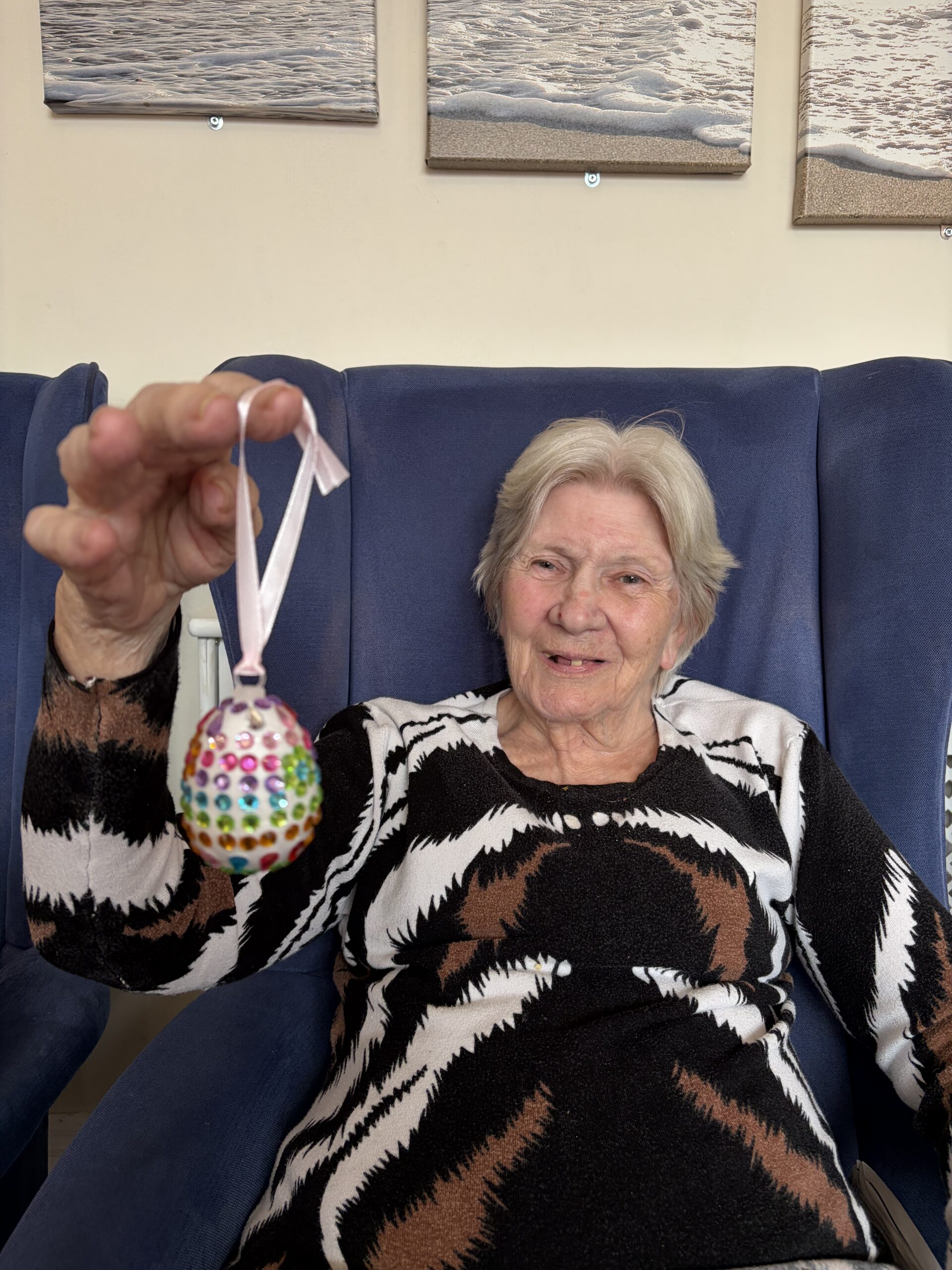 Female resident holding her decorated egg with different coloured sequins