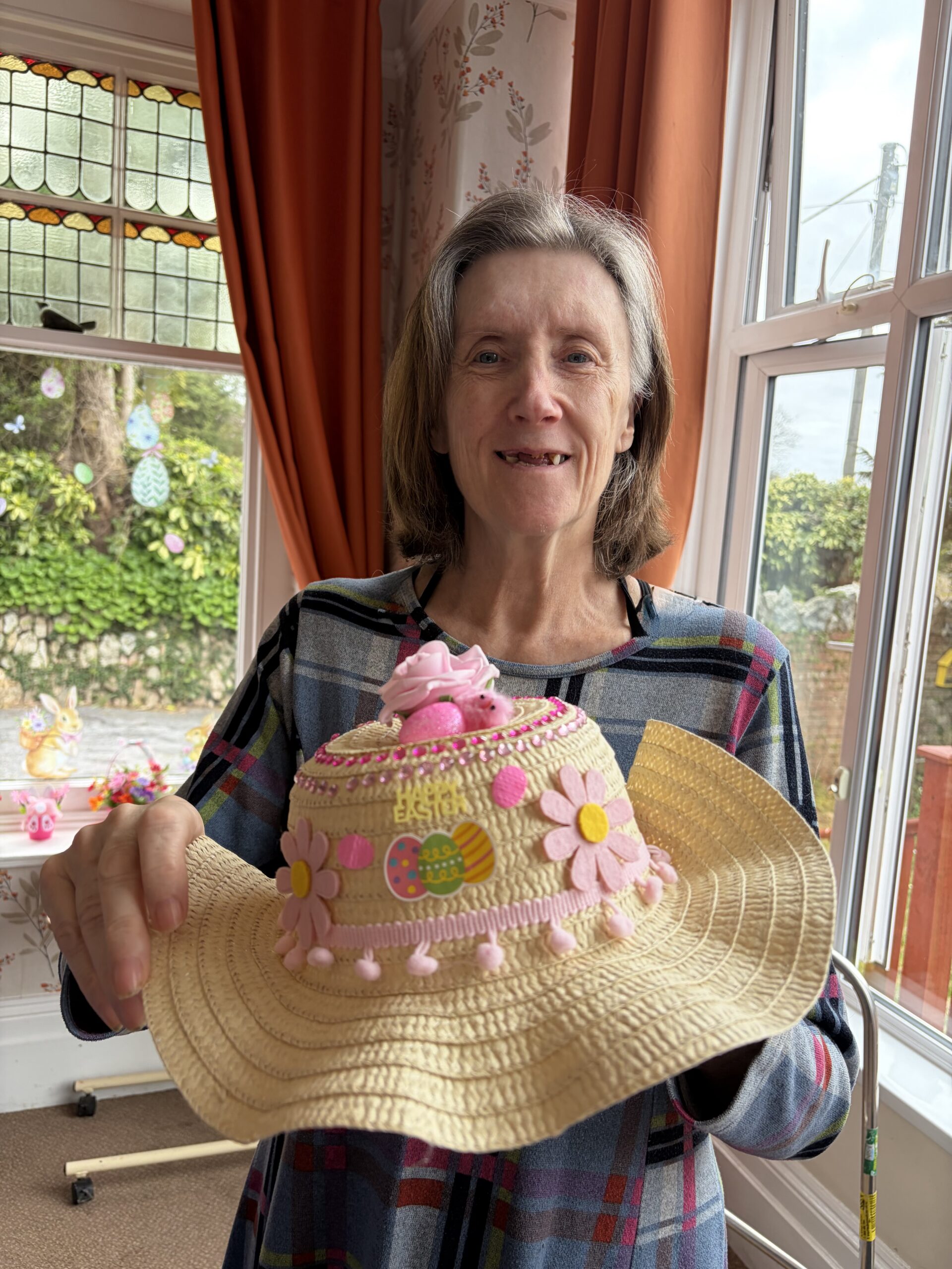 Female resident holding her finished decorated Easter bonnet