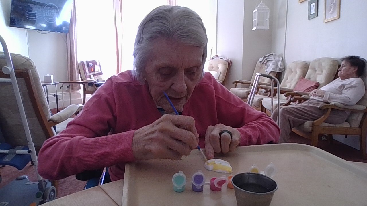 Female resident painting a paper egg