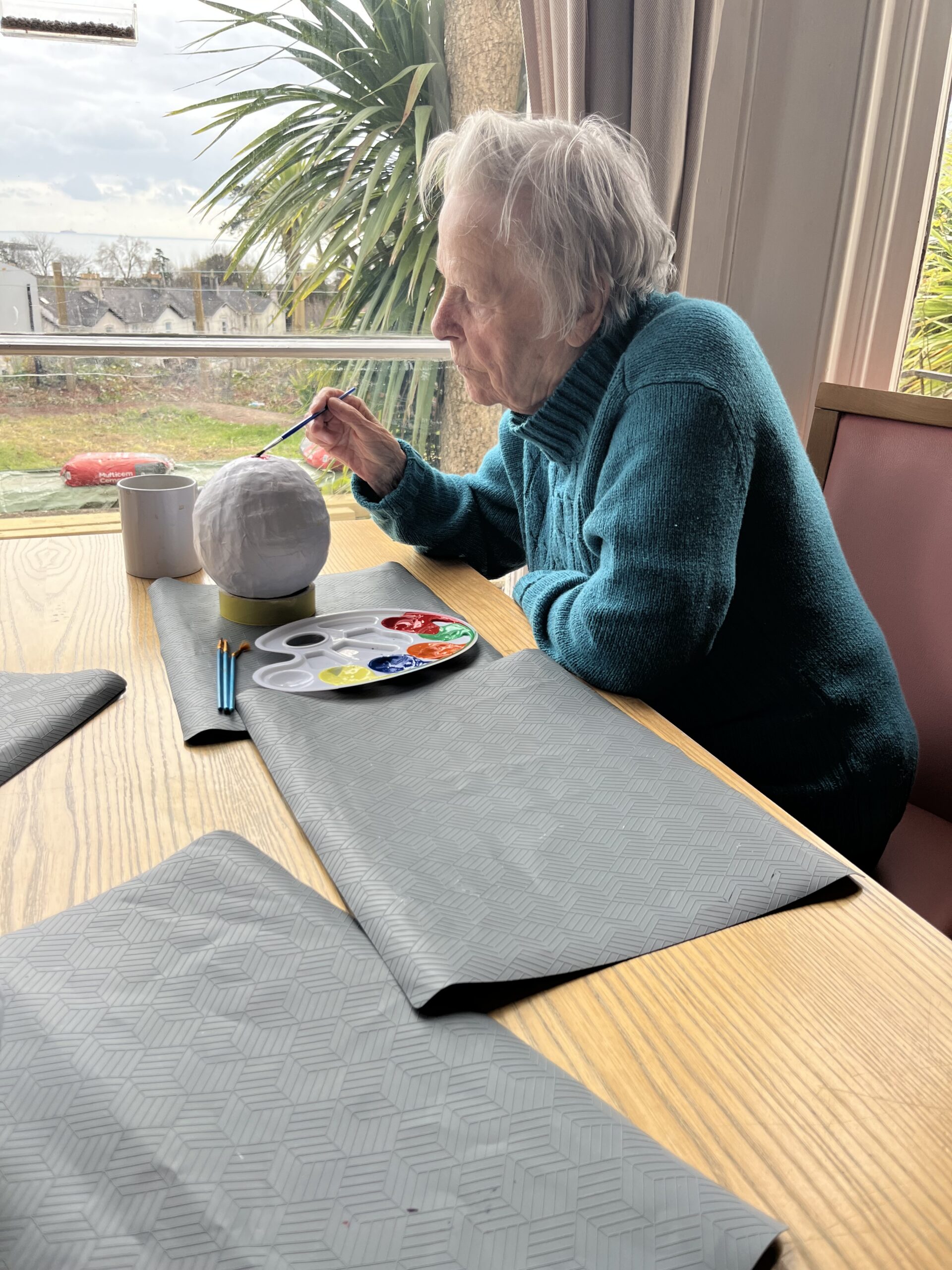 Female resident painting her Easter egg with red paint