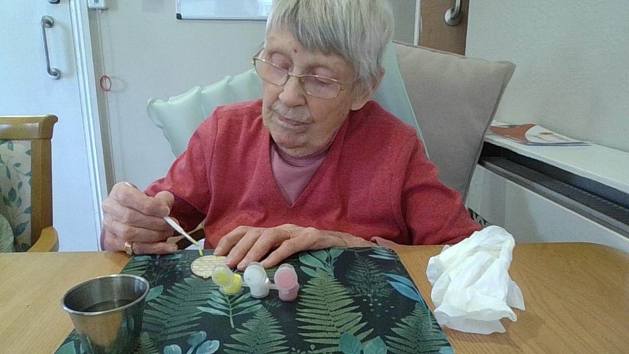 Female resident painting paper egg shape