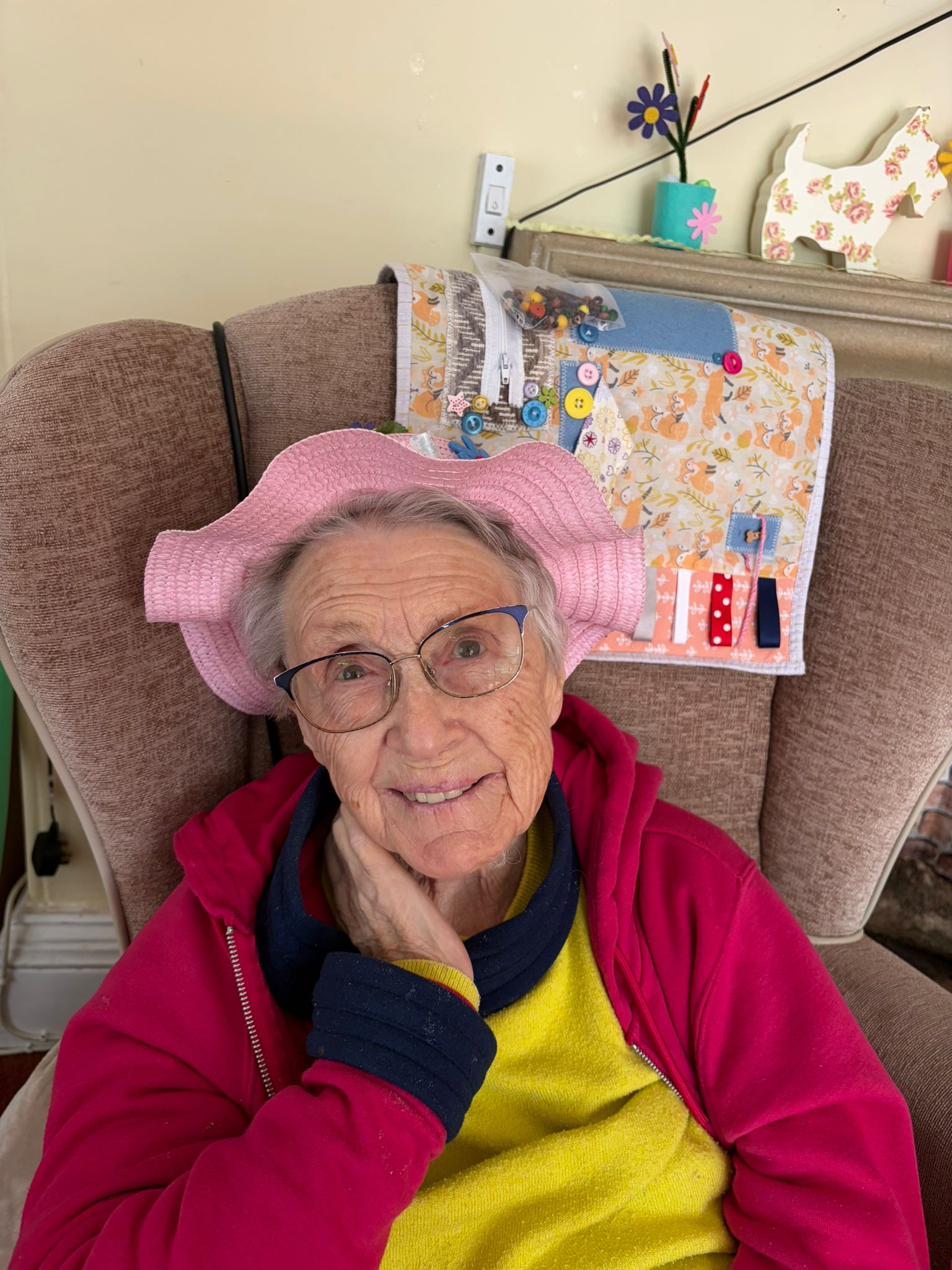 Female resident seated inside with Easter bonnet