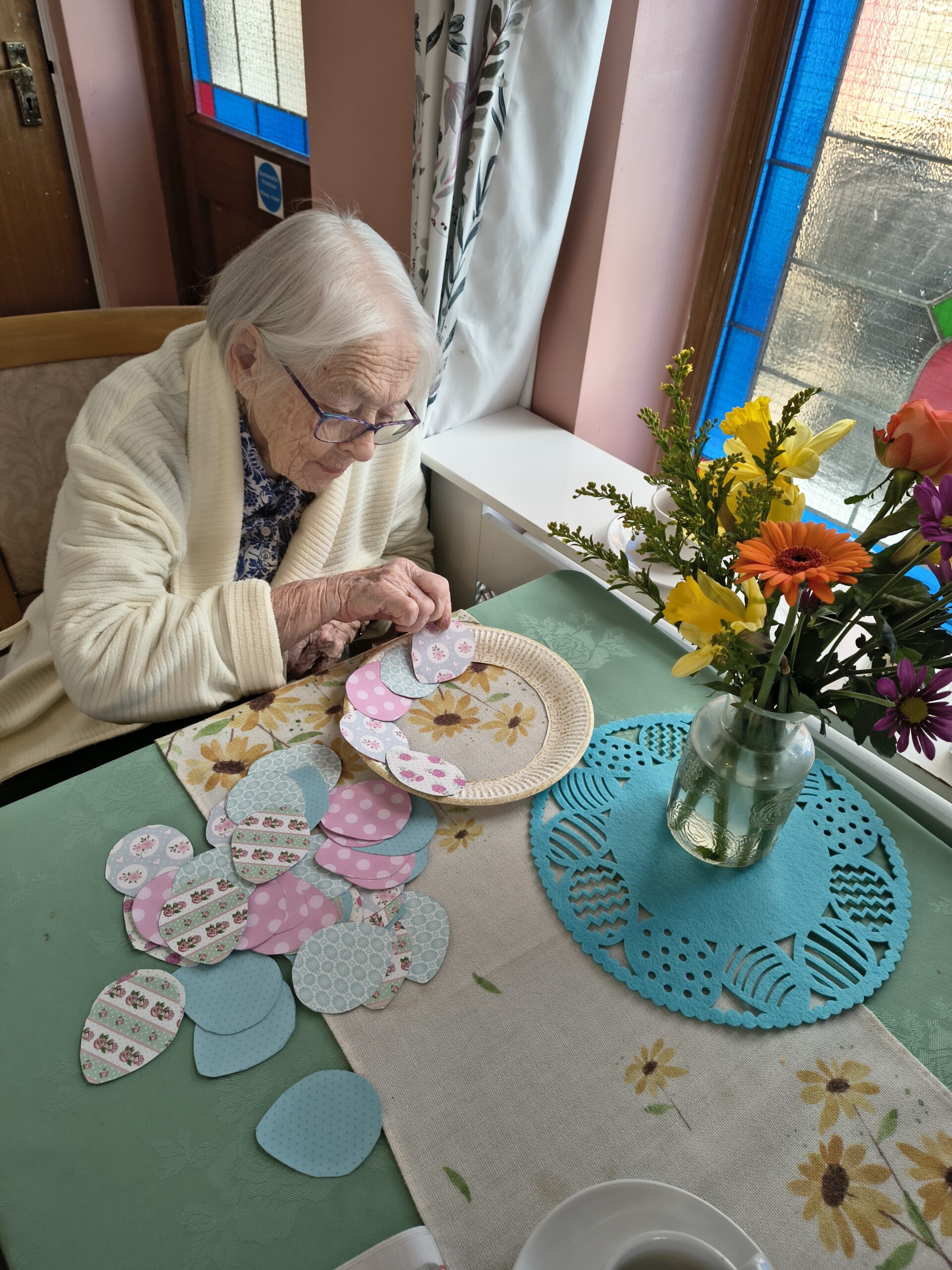 Female resident sticking paper pattern eggs around the wreath 1 scaled