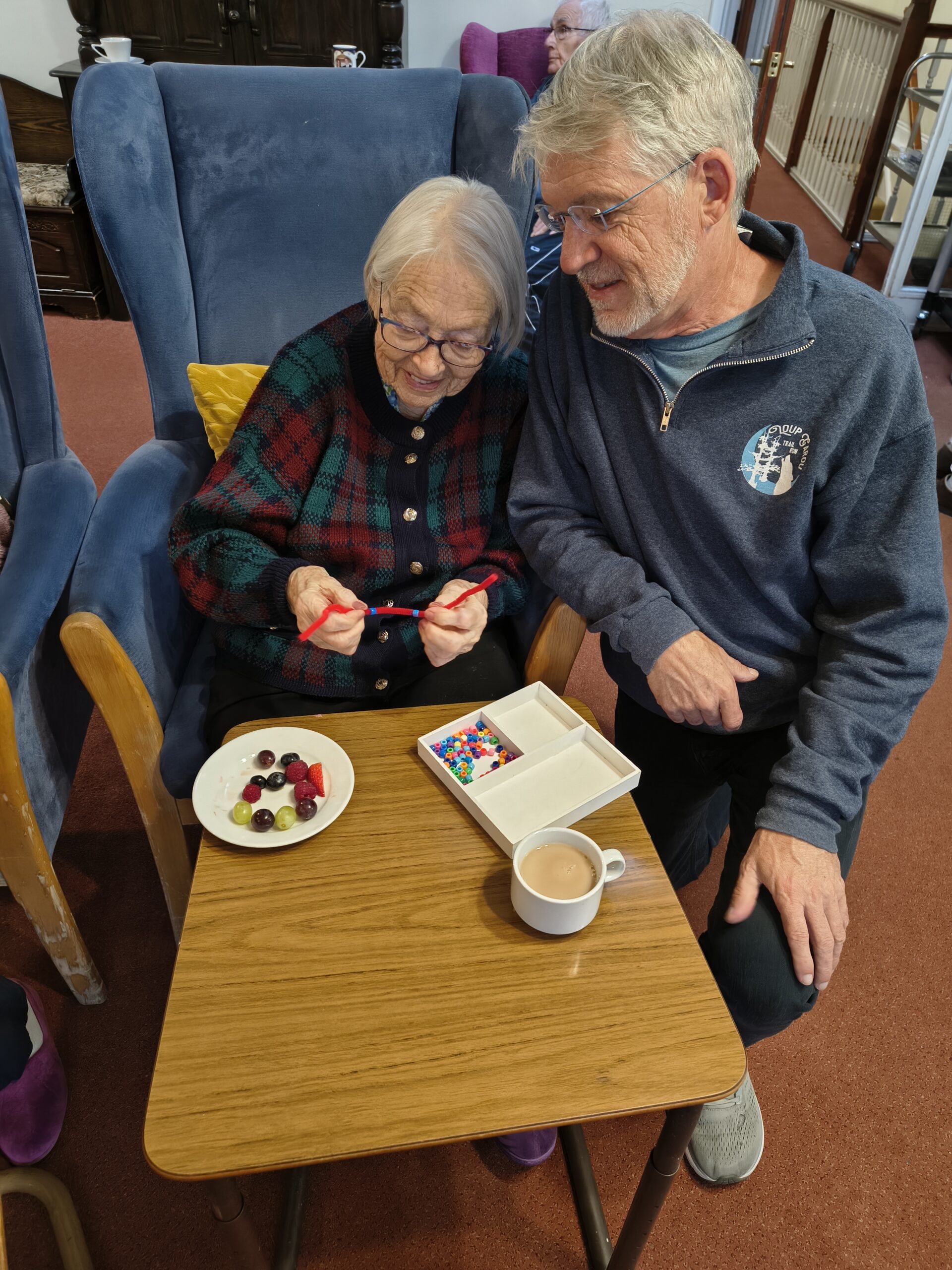 Female resident threading beads onto a pipe cleaner