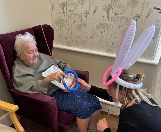Mabel throwing hoop at bunny ears worn by Gemma