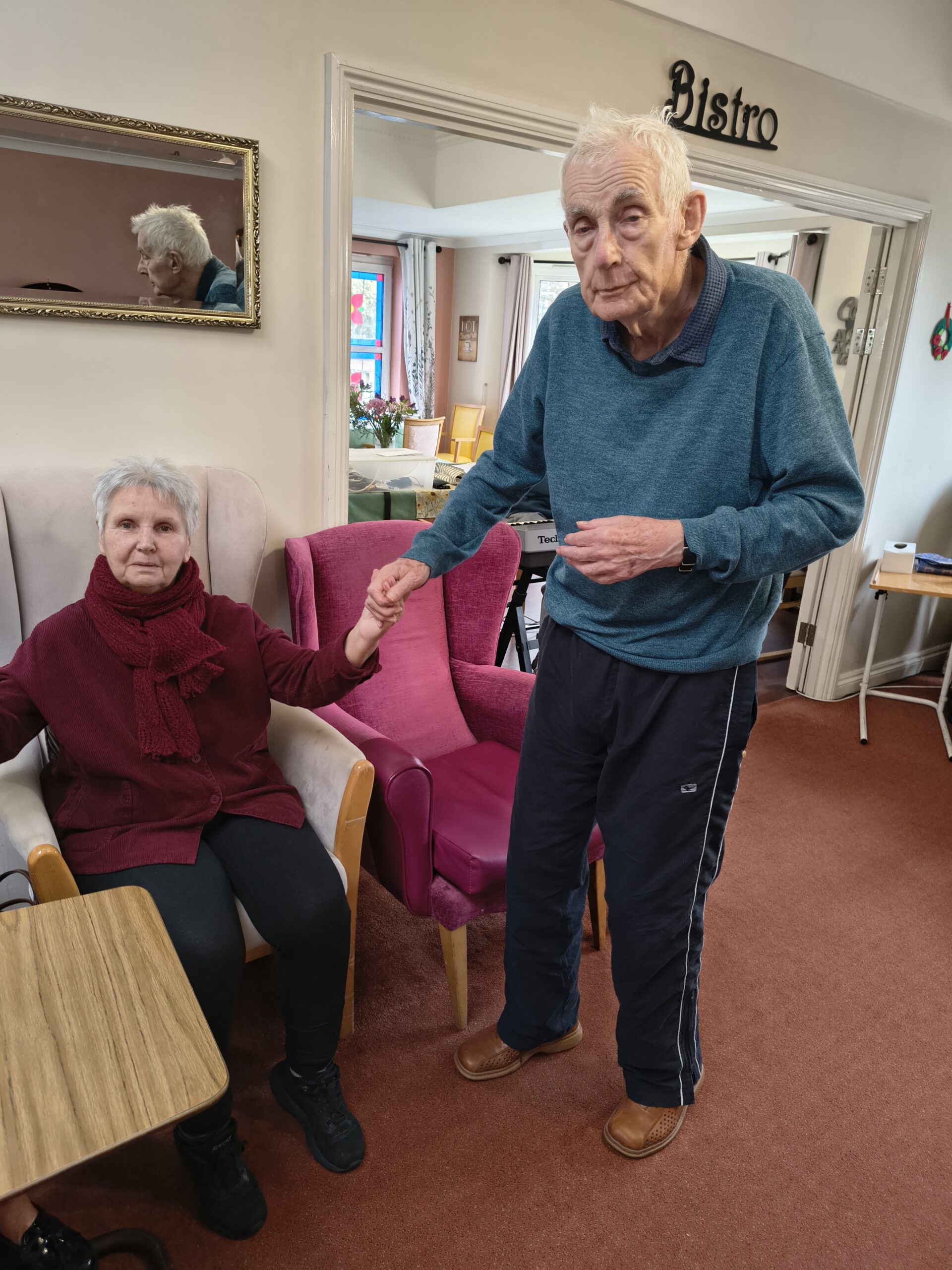 Male and female resident holding hands listening to the keyboard music