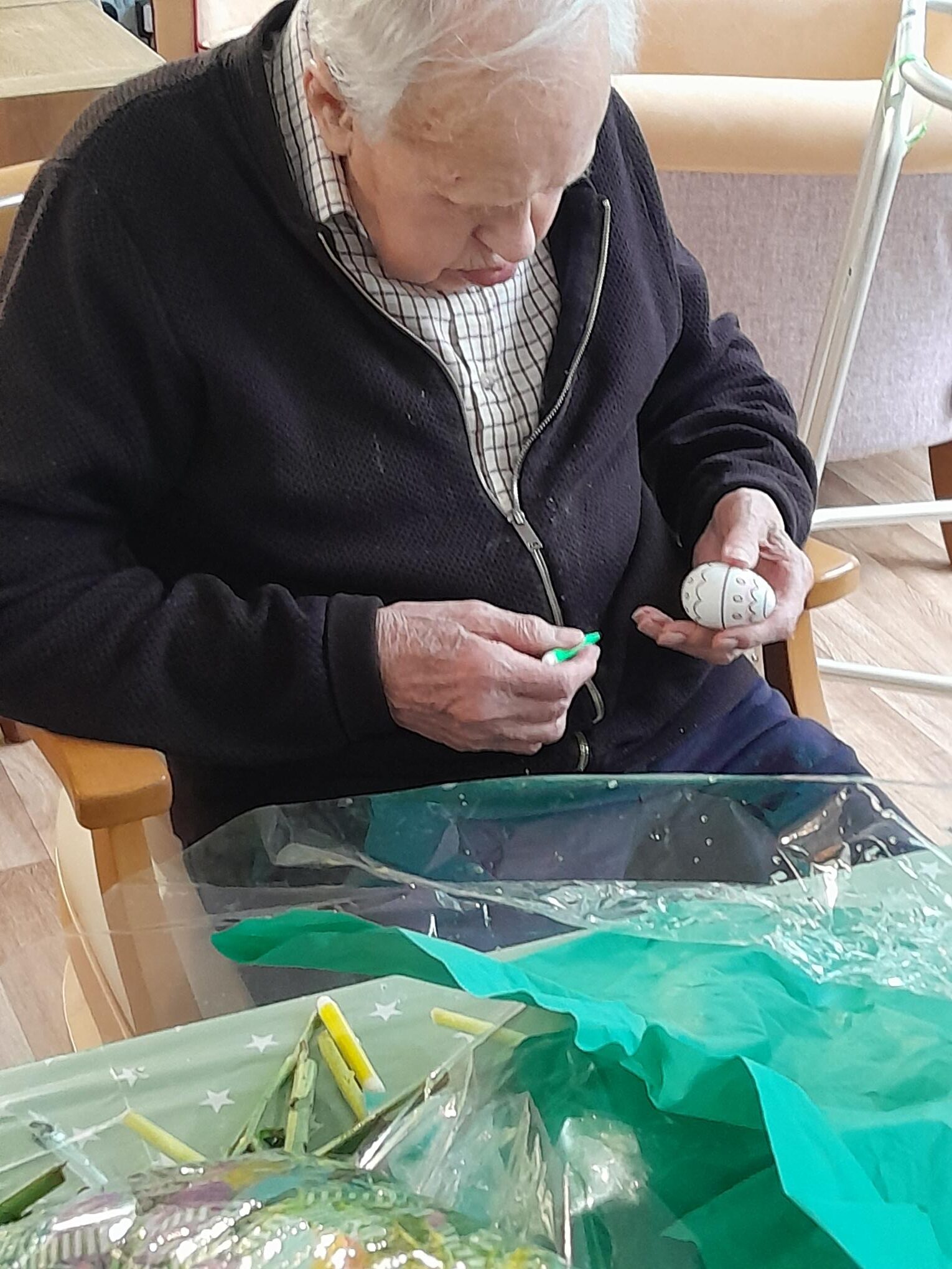 Male resident decorating an egg with felt tip pens rotated