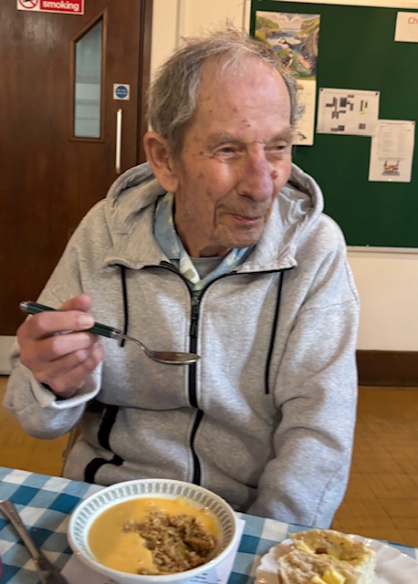Male resident enjoying a bowl of crumble and custard