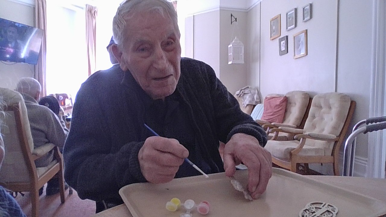 Male resident painting a paper egg