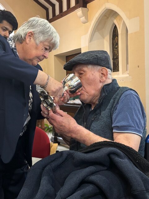Pastor Kim giving Holy Communion to a male resident