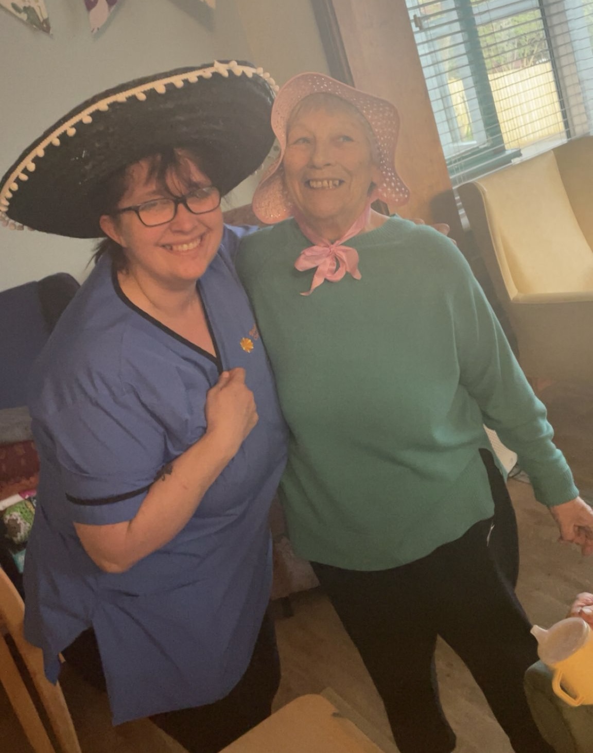 Paula carer in a black sombrero and Ange in a pale pink woven bonnet