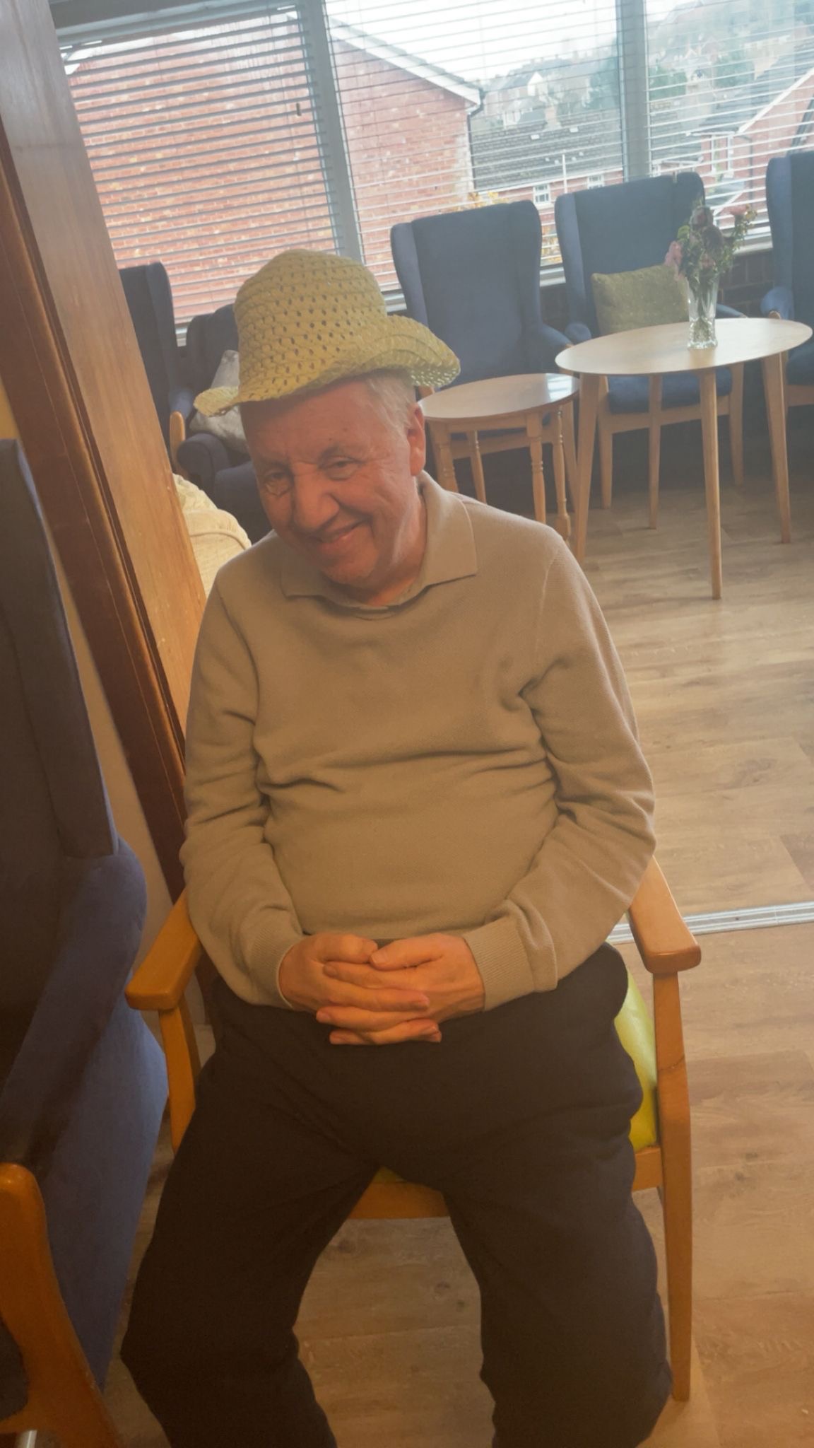 Peter in a pale yellow woven bonnet smiling