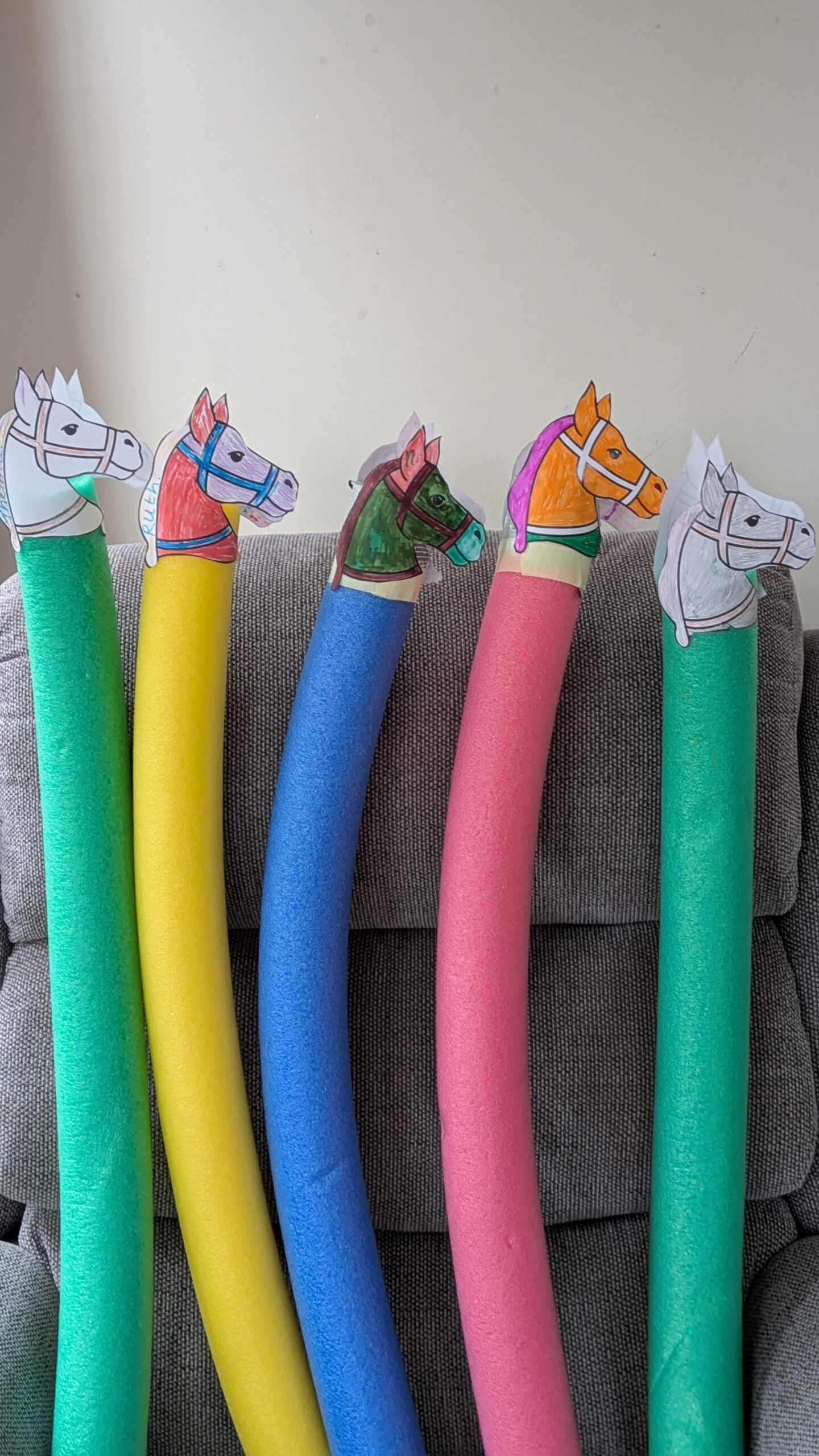 Pool noodles with paper race horse heads