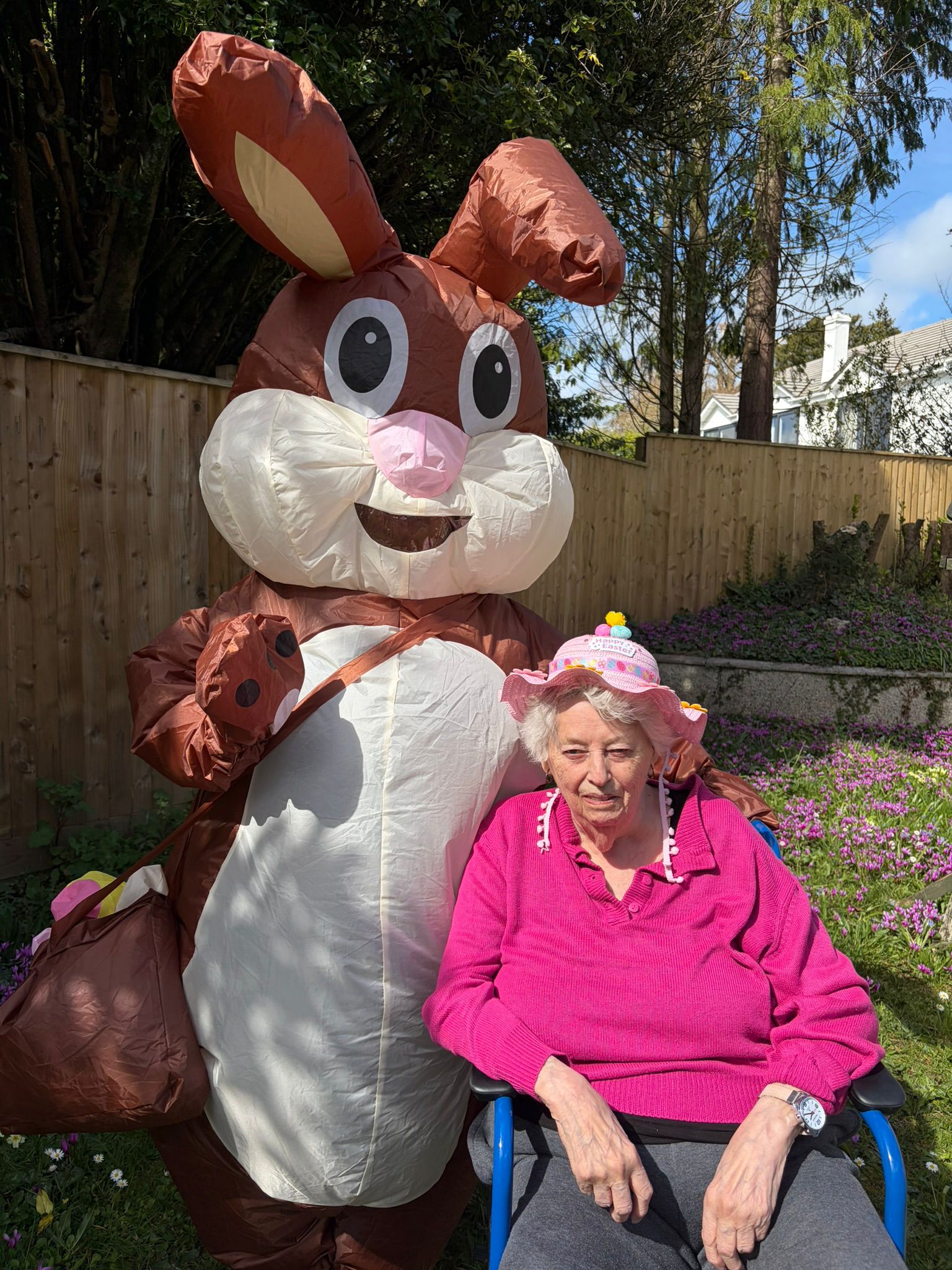 Resident outside in the garden posing for a photo with the Easter bunny
