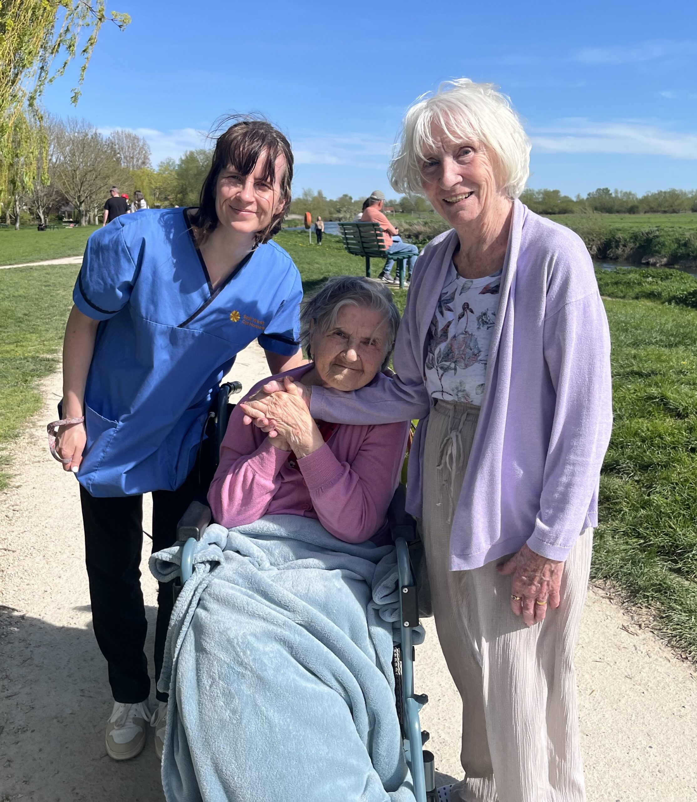 Residents and carer posing for a photograph with the river in the background scaled