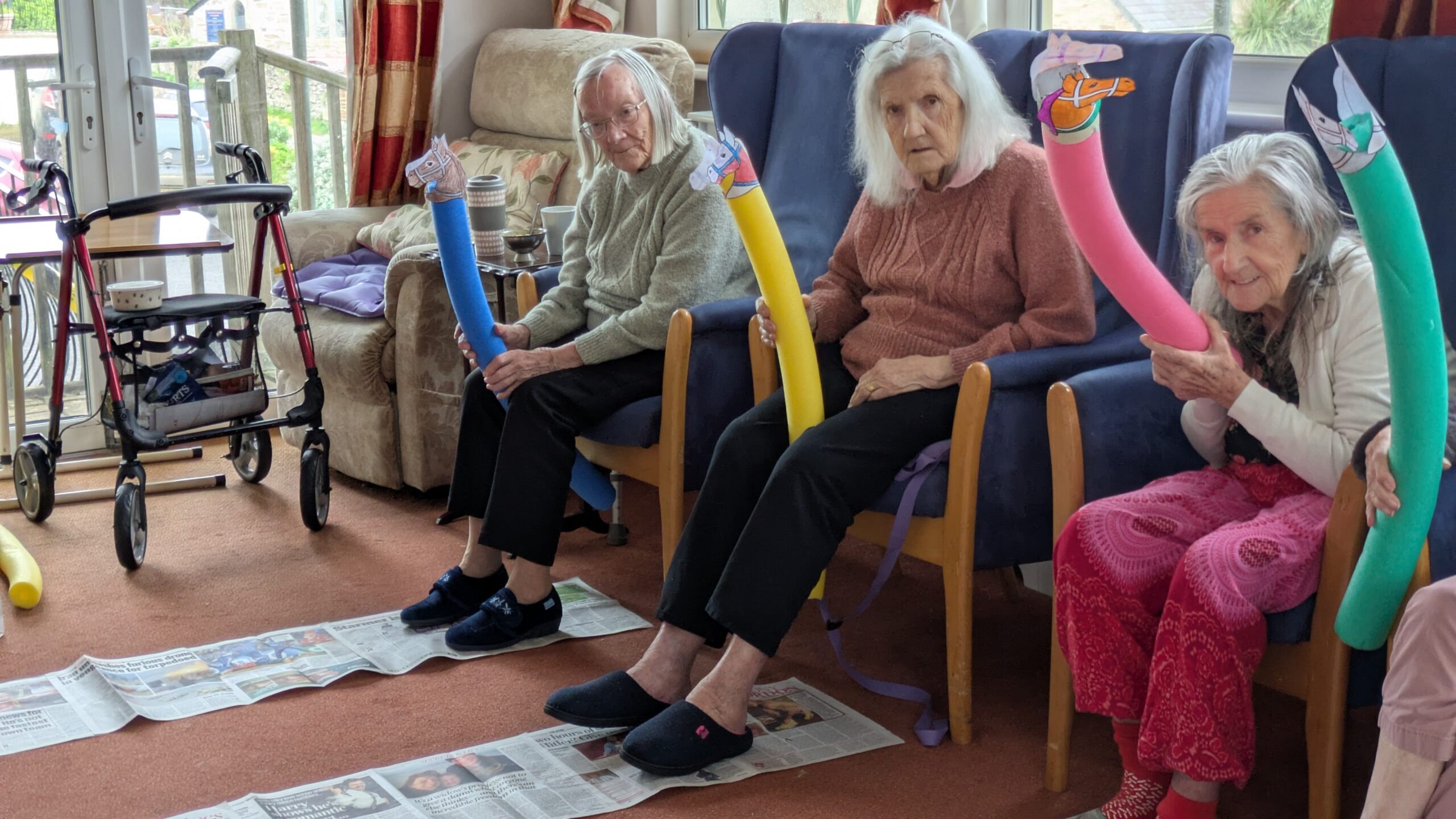 Residents holding their pool noodle race horses at the ready