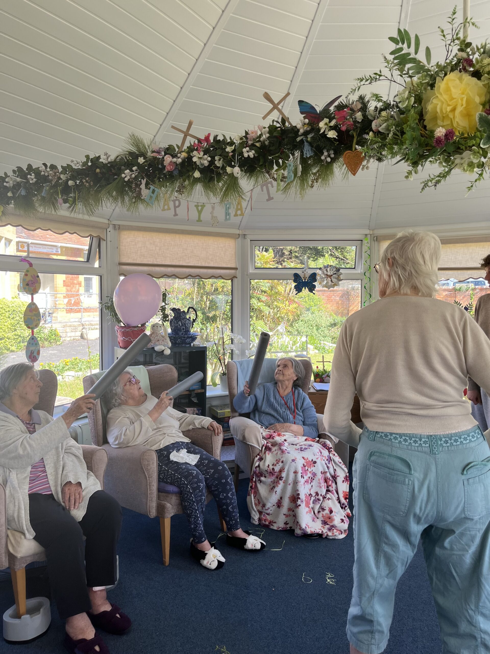 Residents keeping a balloon in the air with foam insulation pipe seated and standing scaled