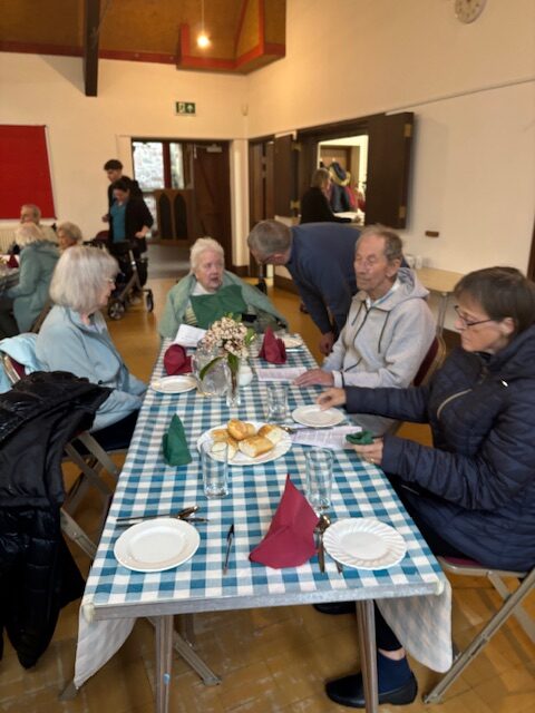 Residents seated around a table chatting