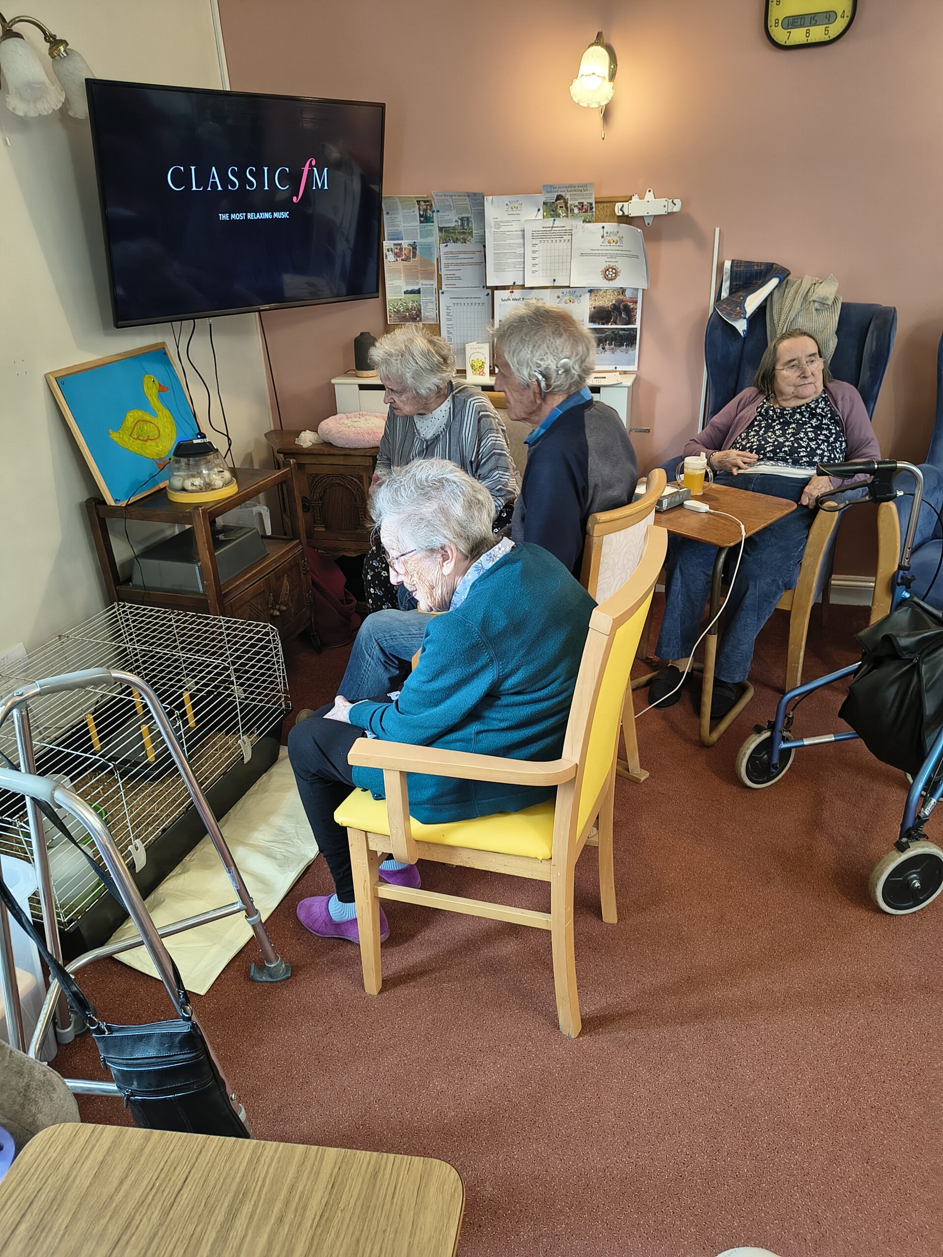 Residents seated around the incubator and cage scaled