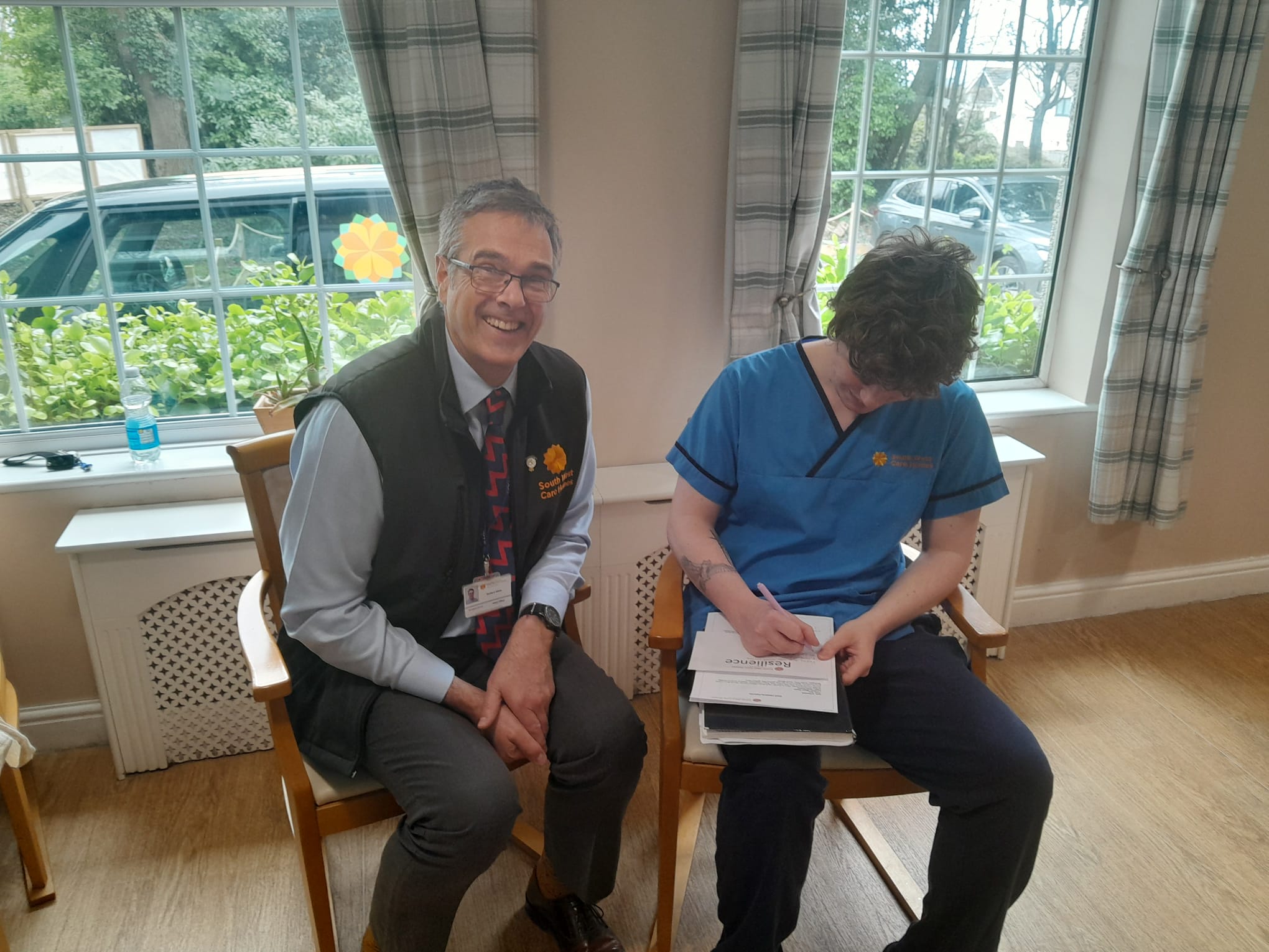 Richard White seated with staff member doing company values exercise