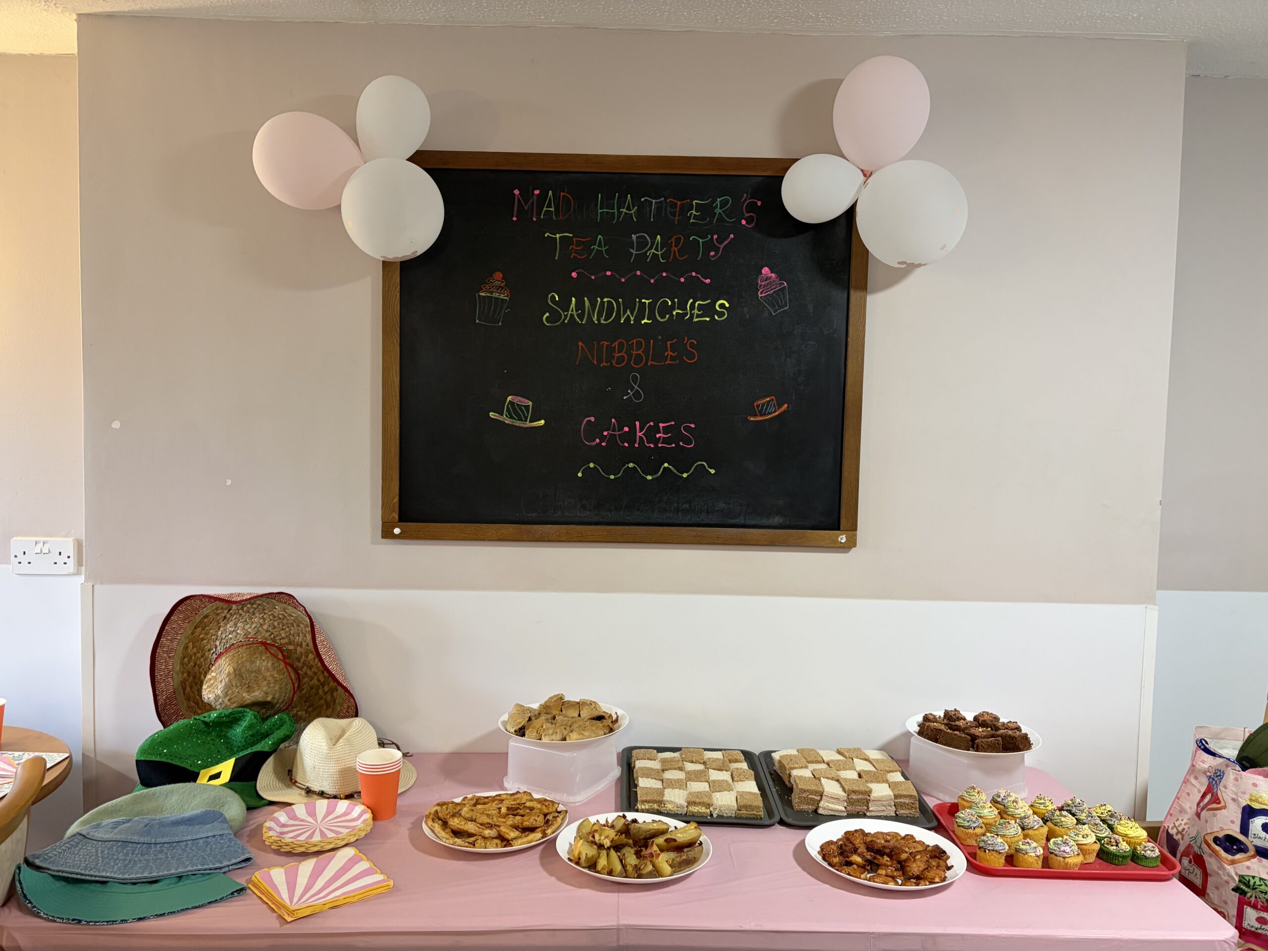 Selection of food and hats for the Mad Hatter's party including checker board sandwiches