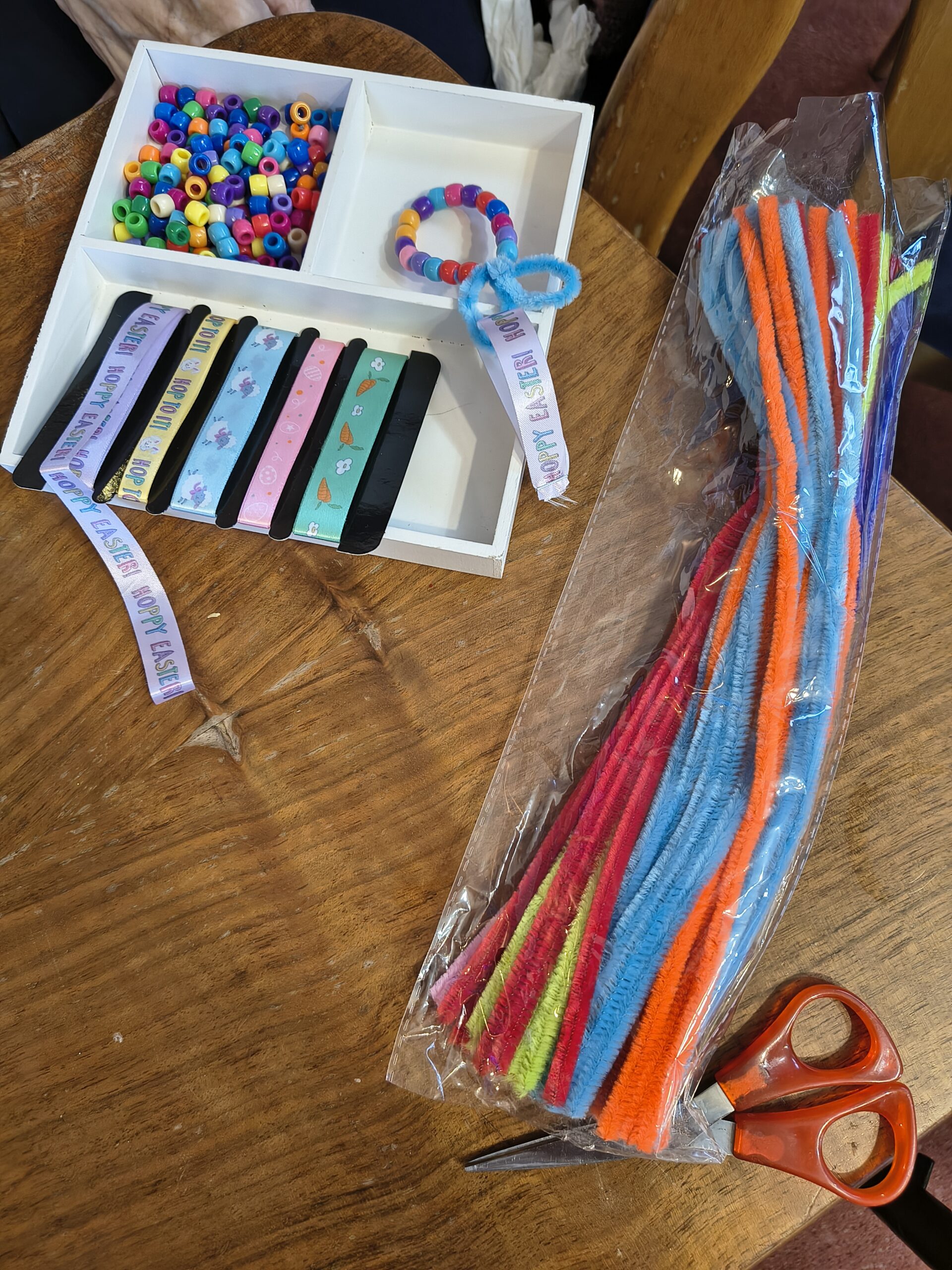 Showing the different materials, coloured pipe cleaners and beads and different Easter ribbons