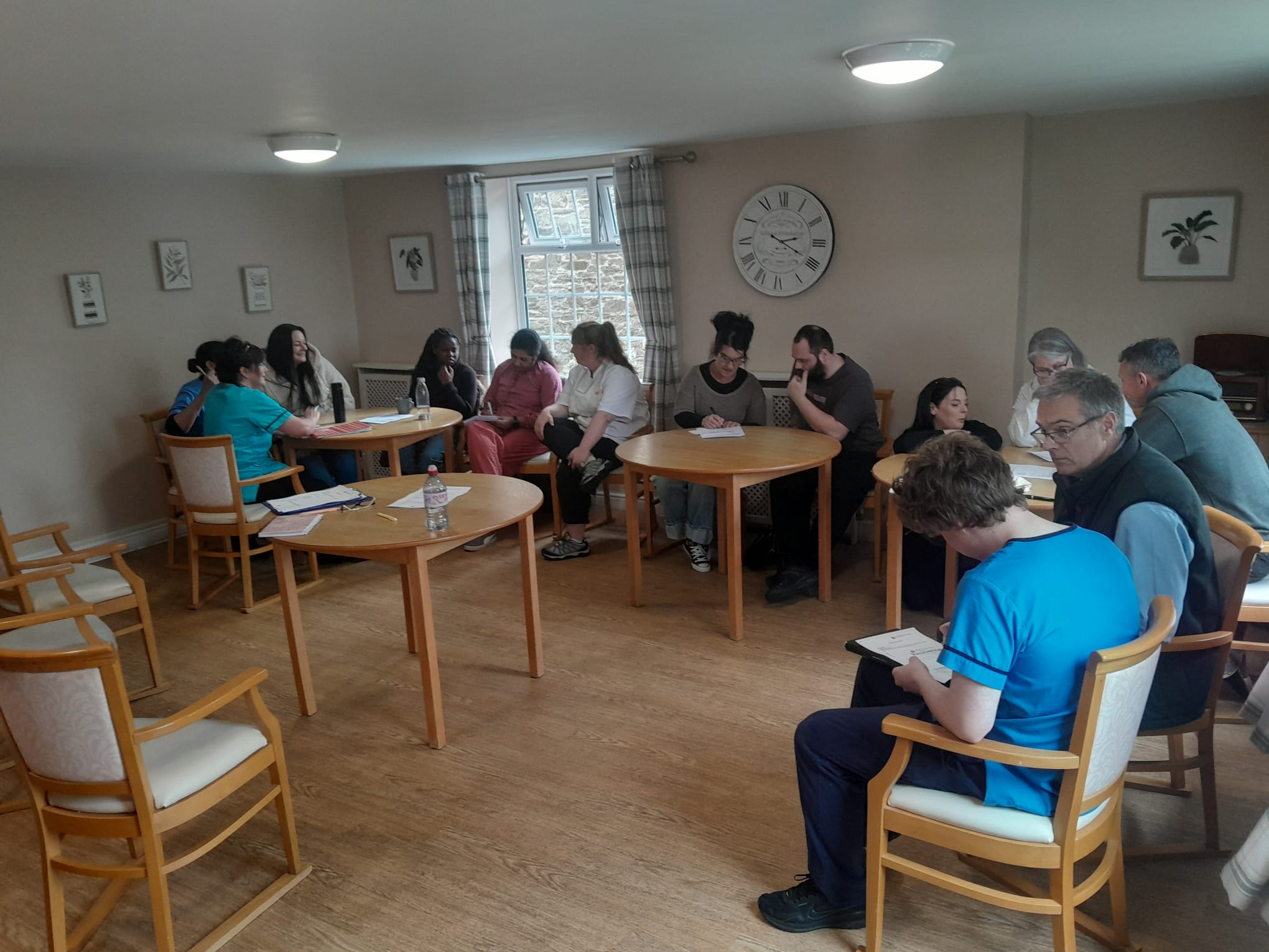 Staff seated around tables in small groups doing the company values exercise