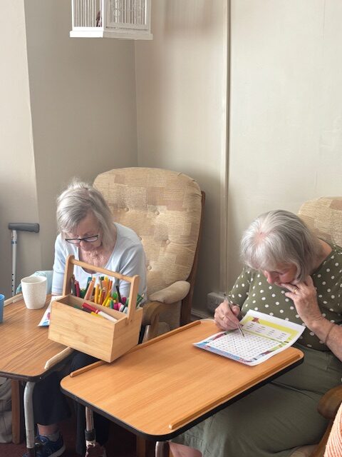 Two female residents doing a St Georges day themed word search puzzle rotated