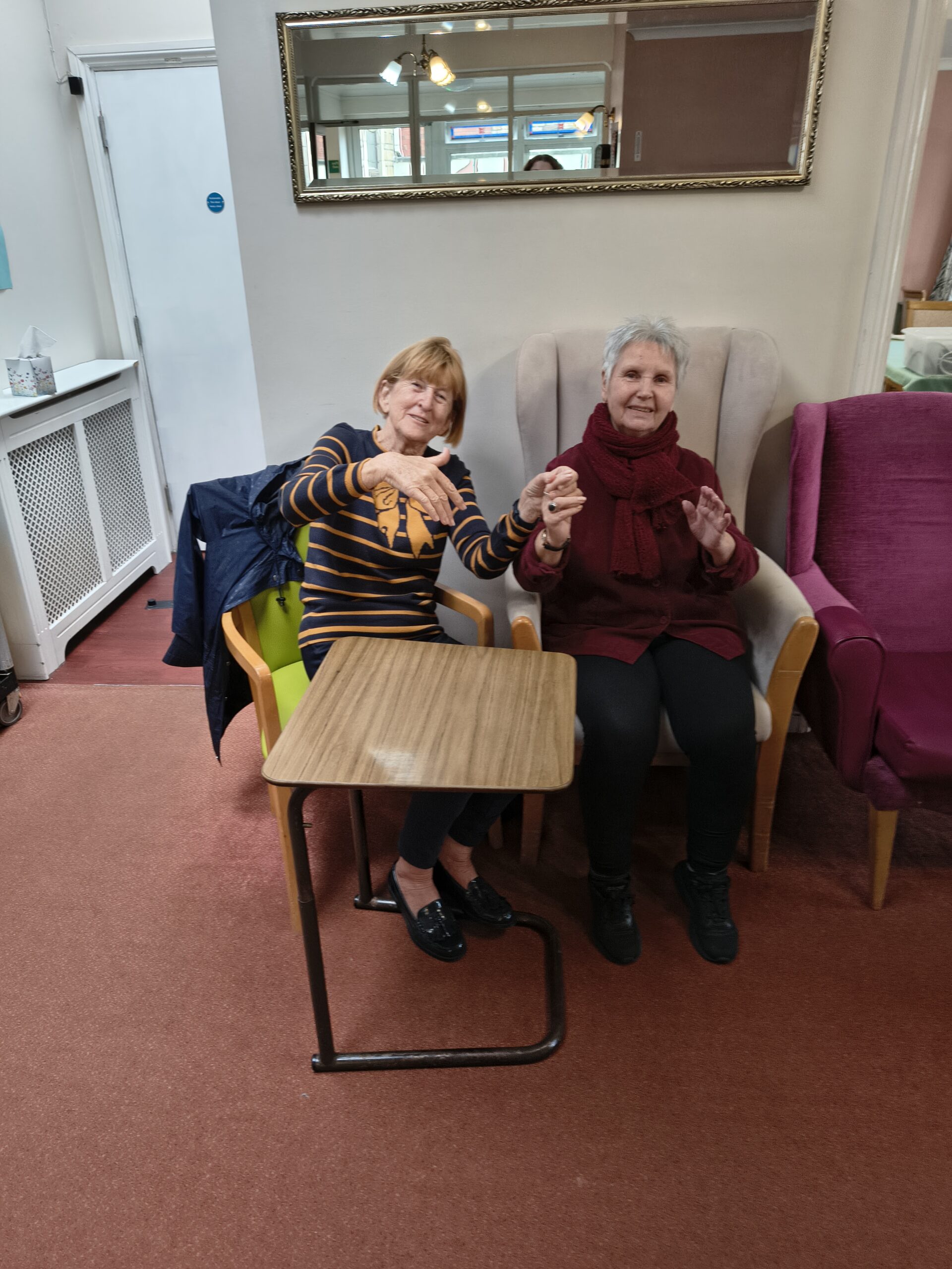 Two female residents holding hands swinging to the music