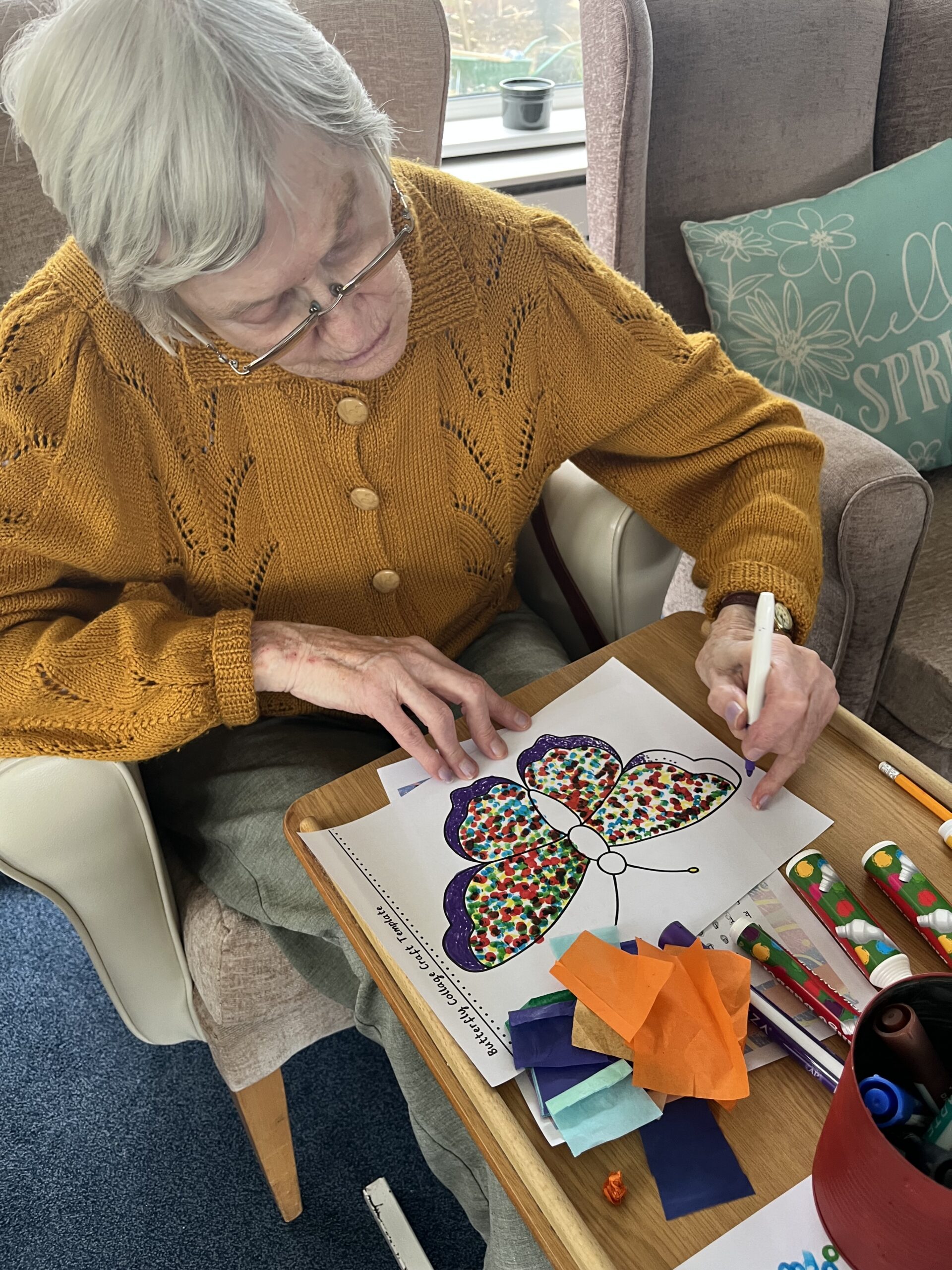 Wendy adding texture to her butterfly artwork with felt-tip pen and tissue paper