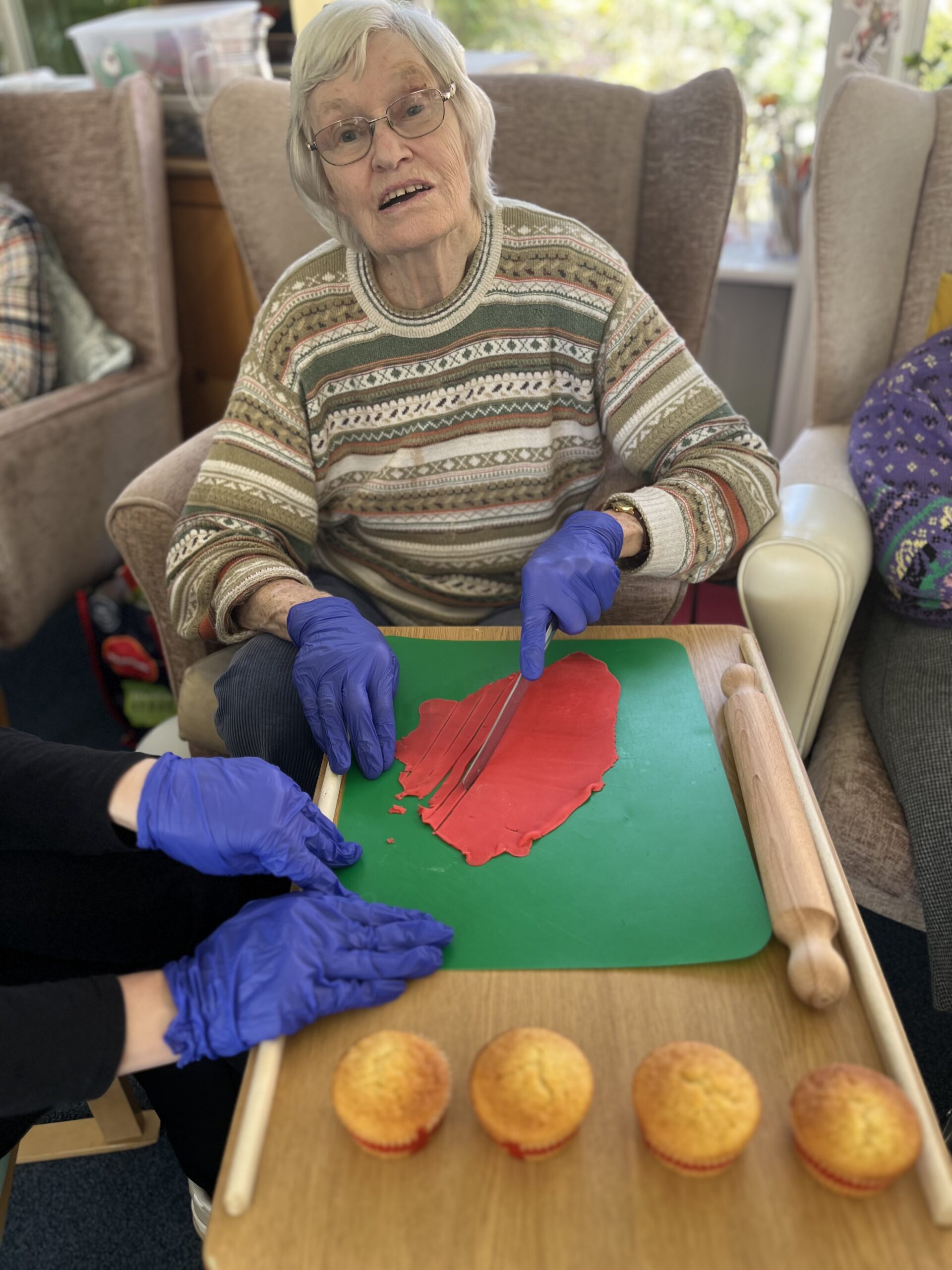 Wendy cutting red icing into strips for cupcake decoration scaled