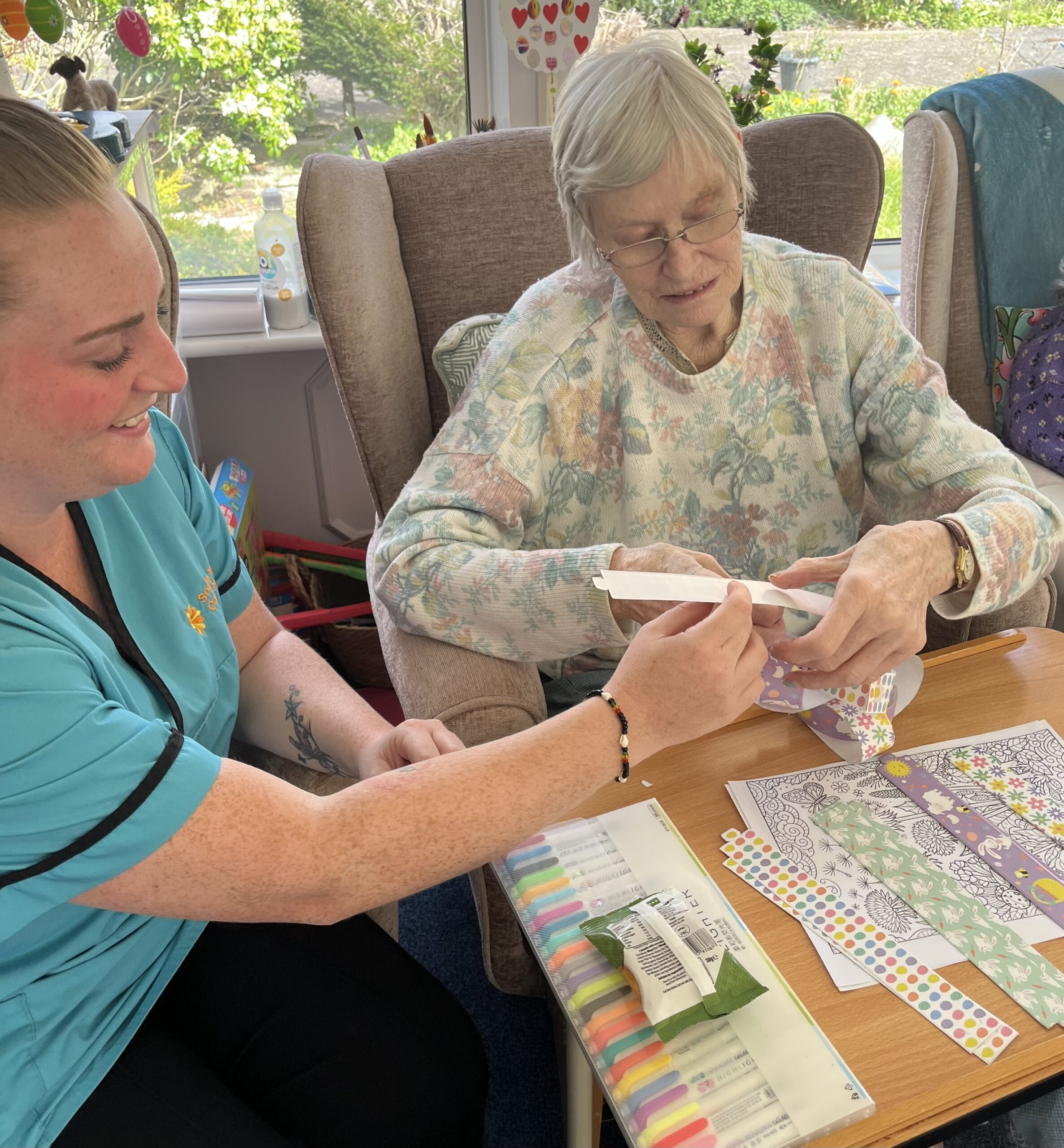 Wendy doing Easter paper crafts with a carer scaled