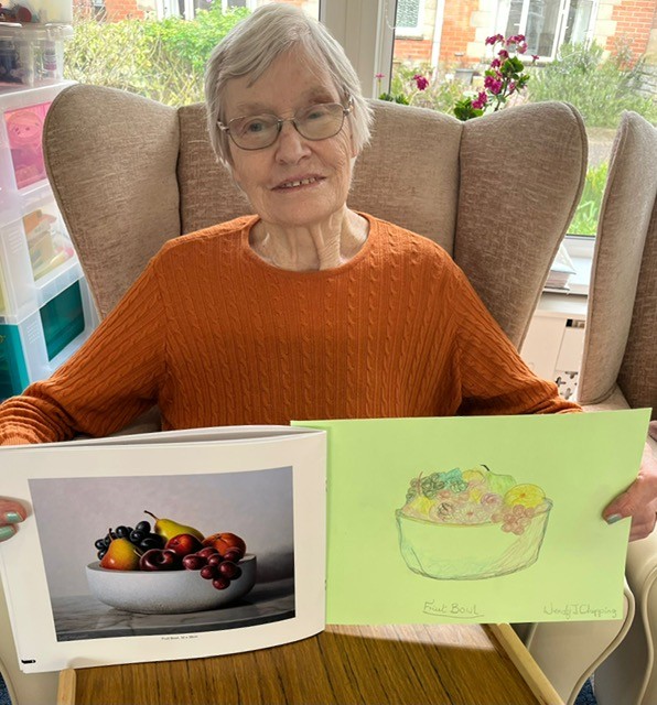 Wendy showing her colour pencil drawing of a fruit bowl