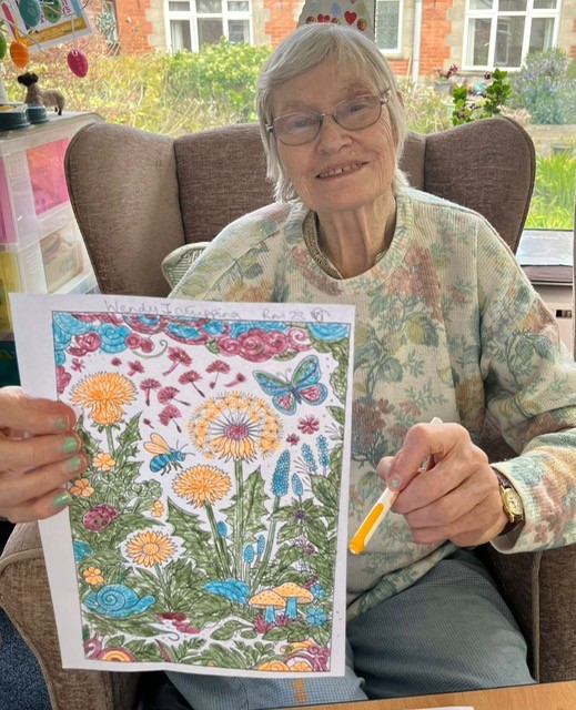 Wendy showing her felt tip colouring in of dandelions and butterflies